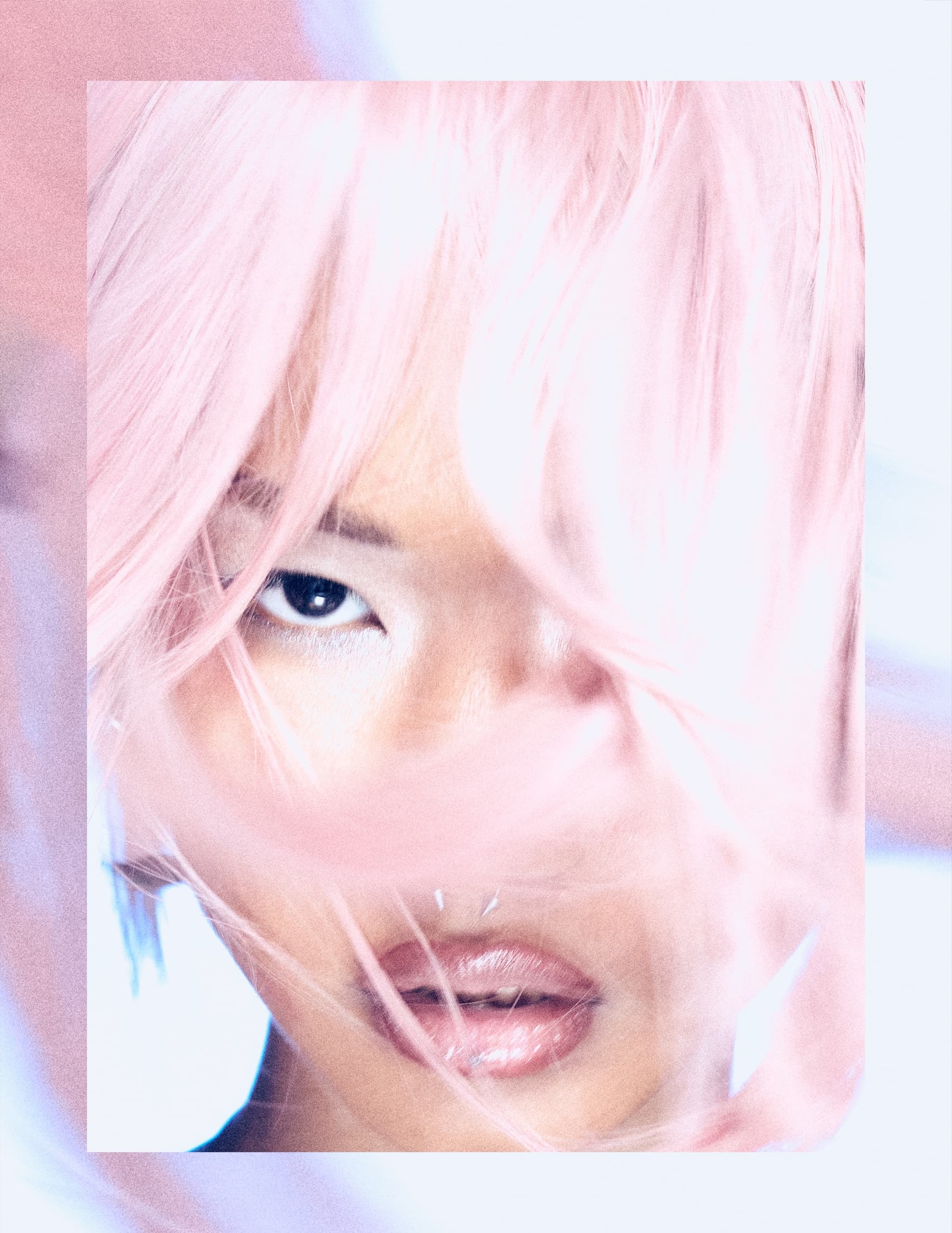 Close-up portrait with pastel pink hair covering part of face, focused eyes.