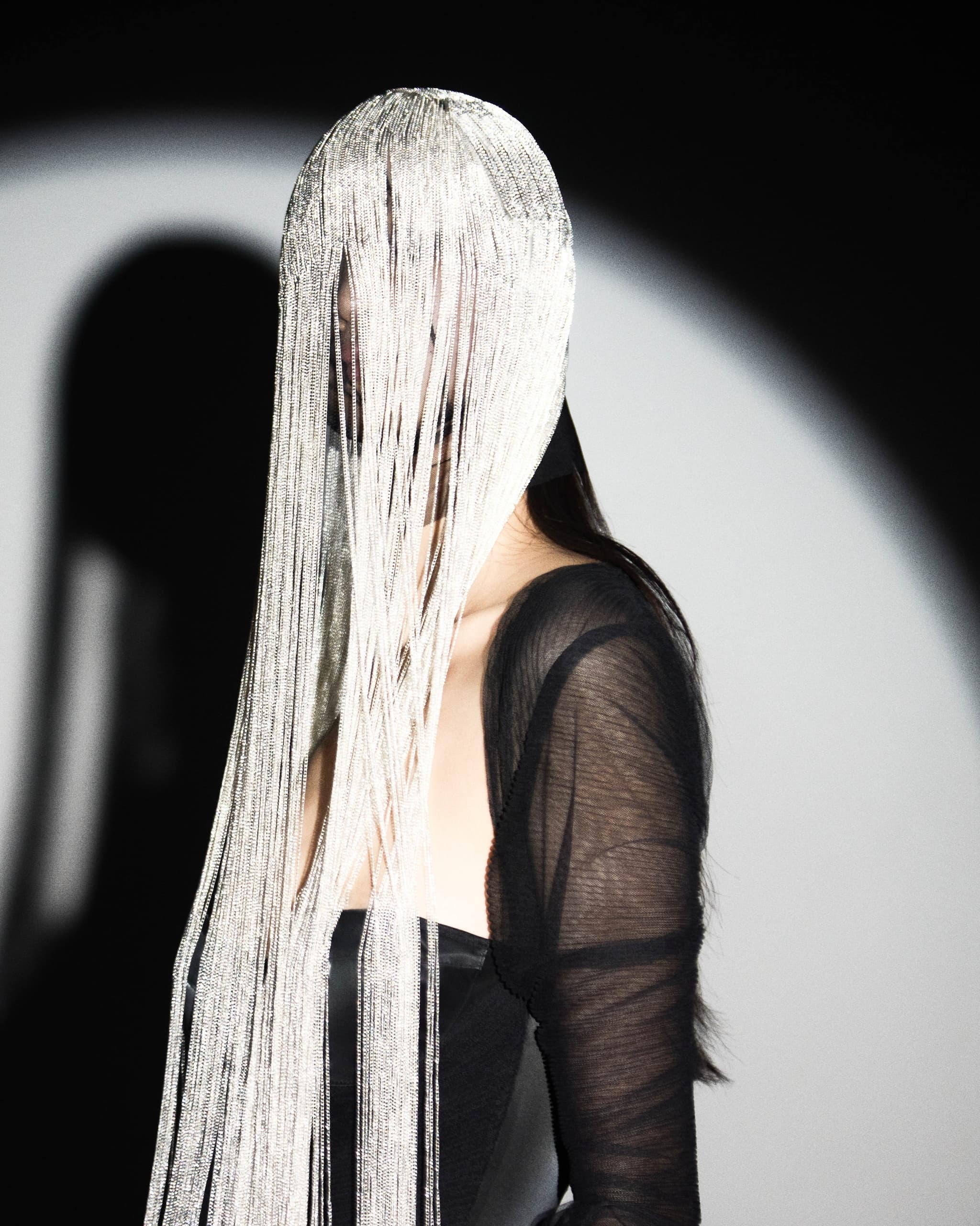 Mystical woman in fringe headpiece, dramatic fashion photography.