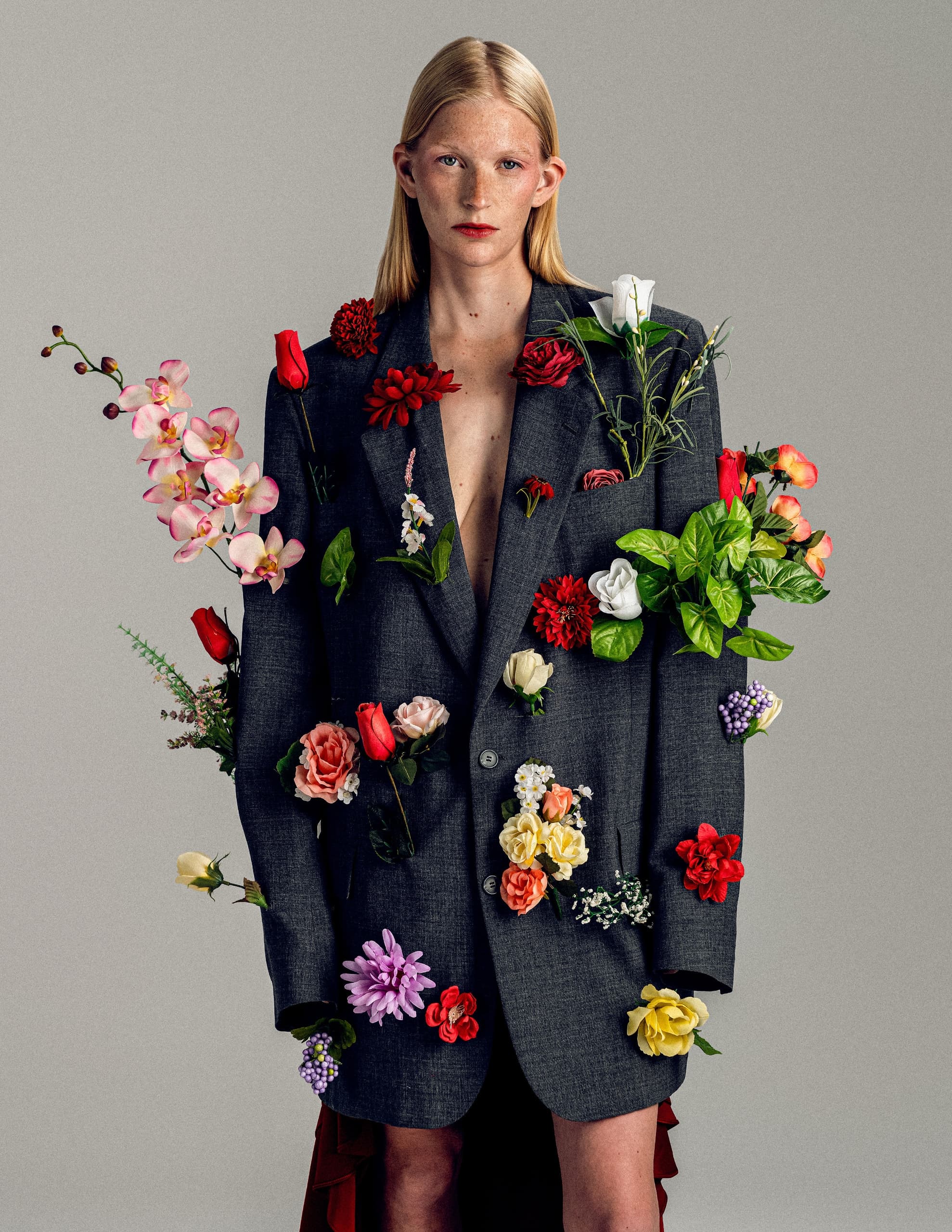 Model in floral-decorated oversized blazer, blending fashion and nature.