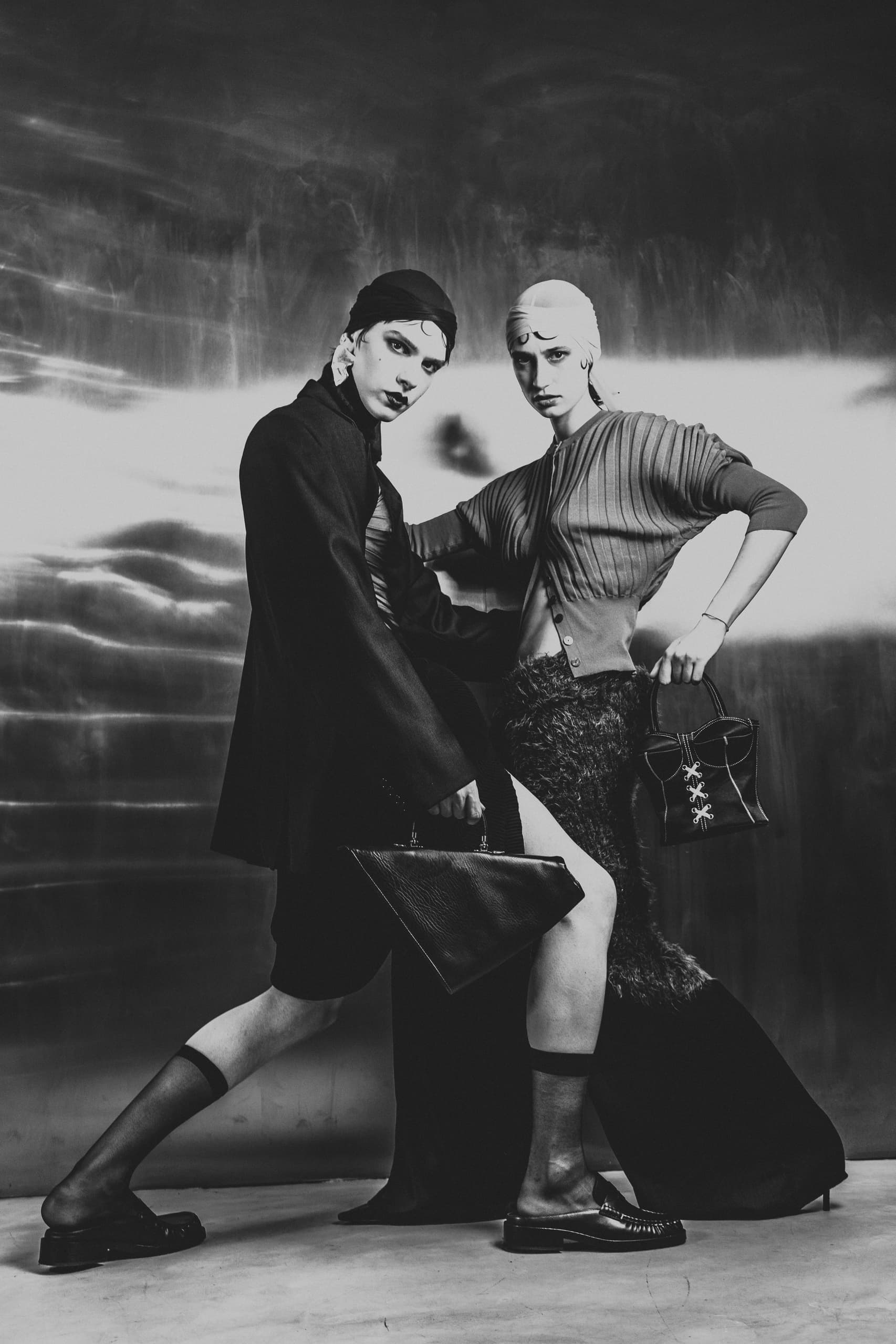 Fashion models in stylish black and white attire pose for an avant-garde photoshoot.