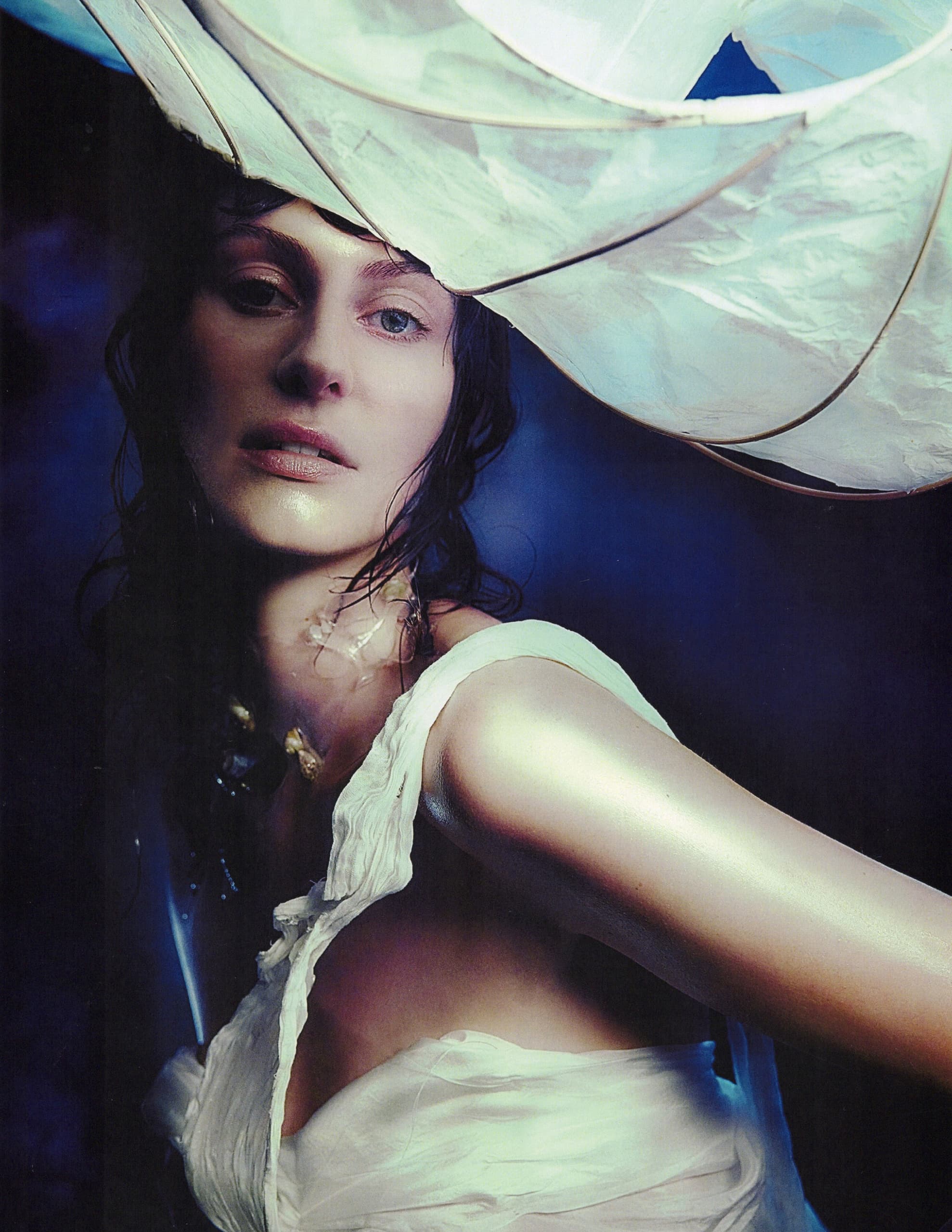 Artistic portrait of a woman with flowing fabric and soft lighting.
