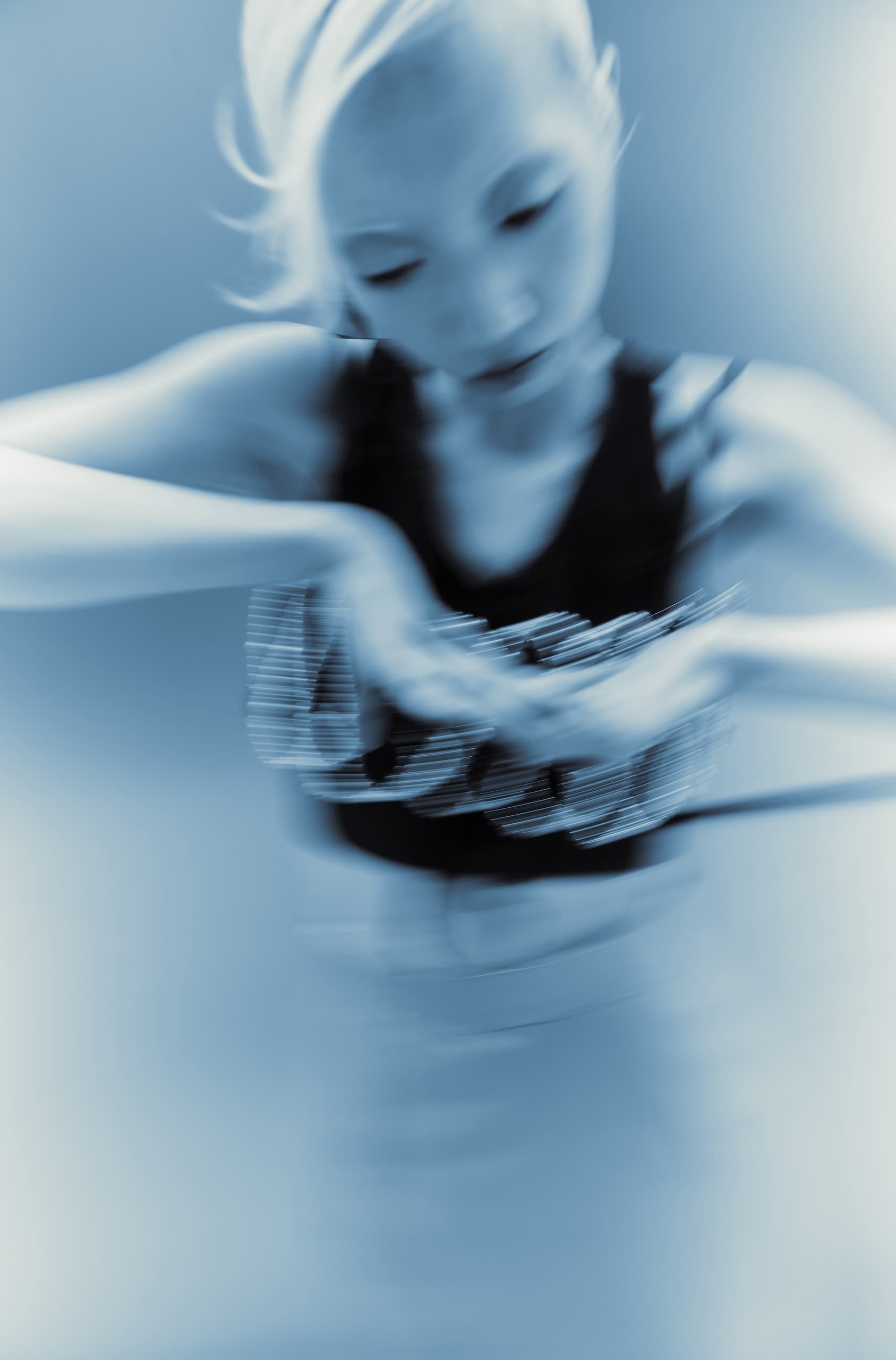Blurred motion of a dancer in a dynamic, blue-toned image.
