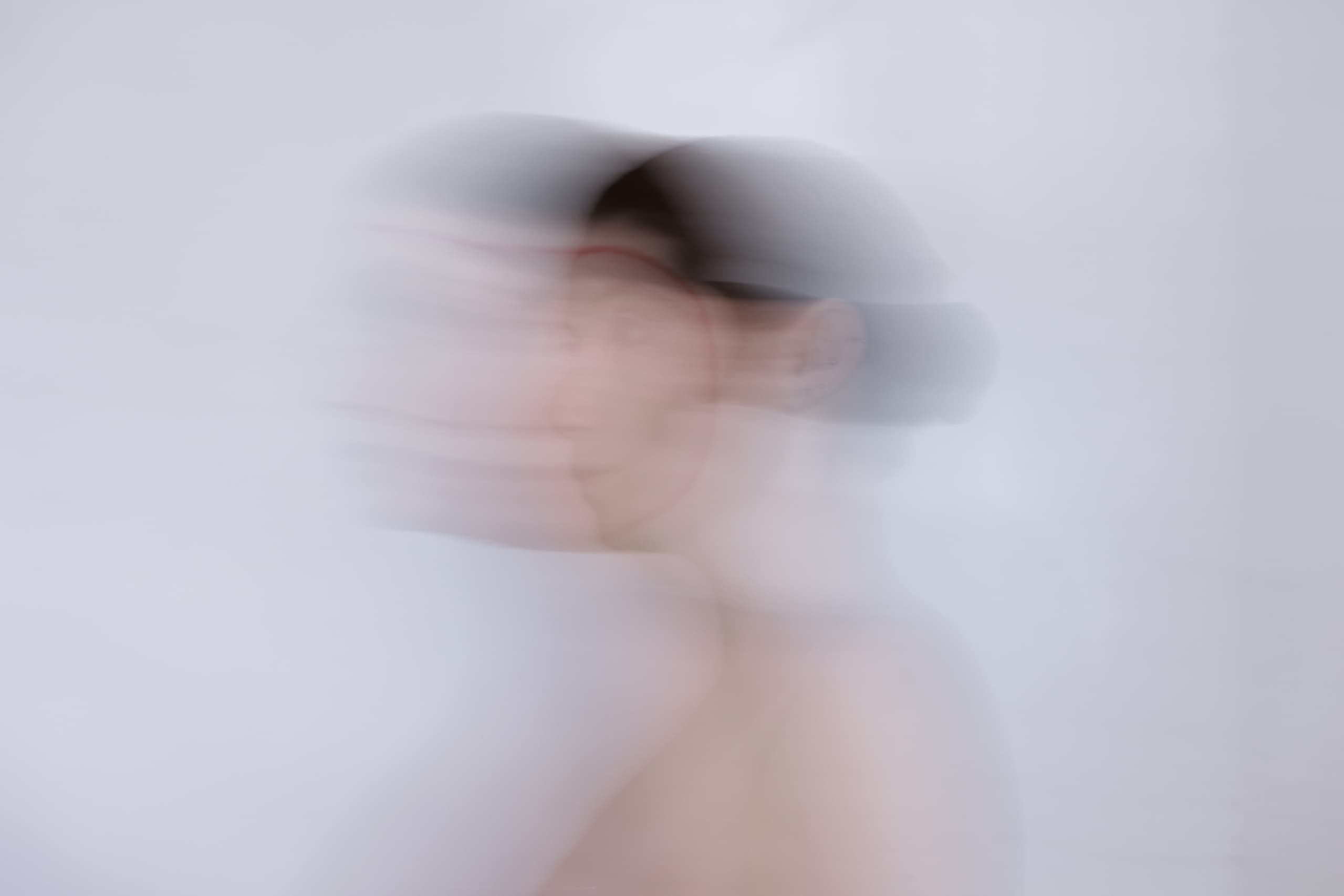 Abstract blurred motion photo of a woman's face in soft light.