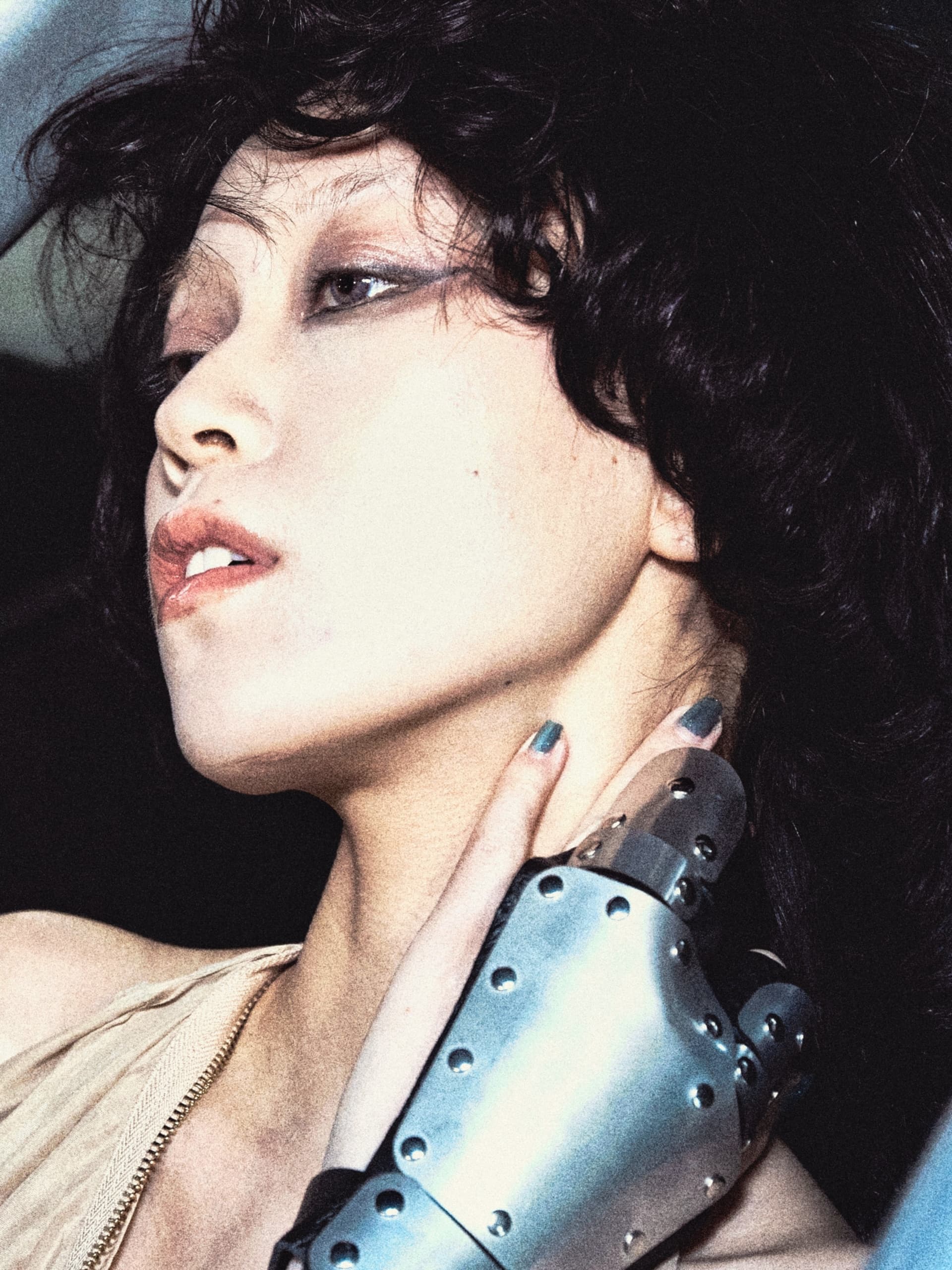 Person with robotic hand, looking contemplative, in dramatic lighting.