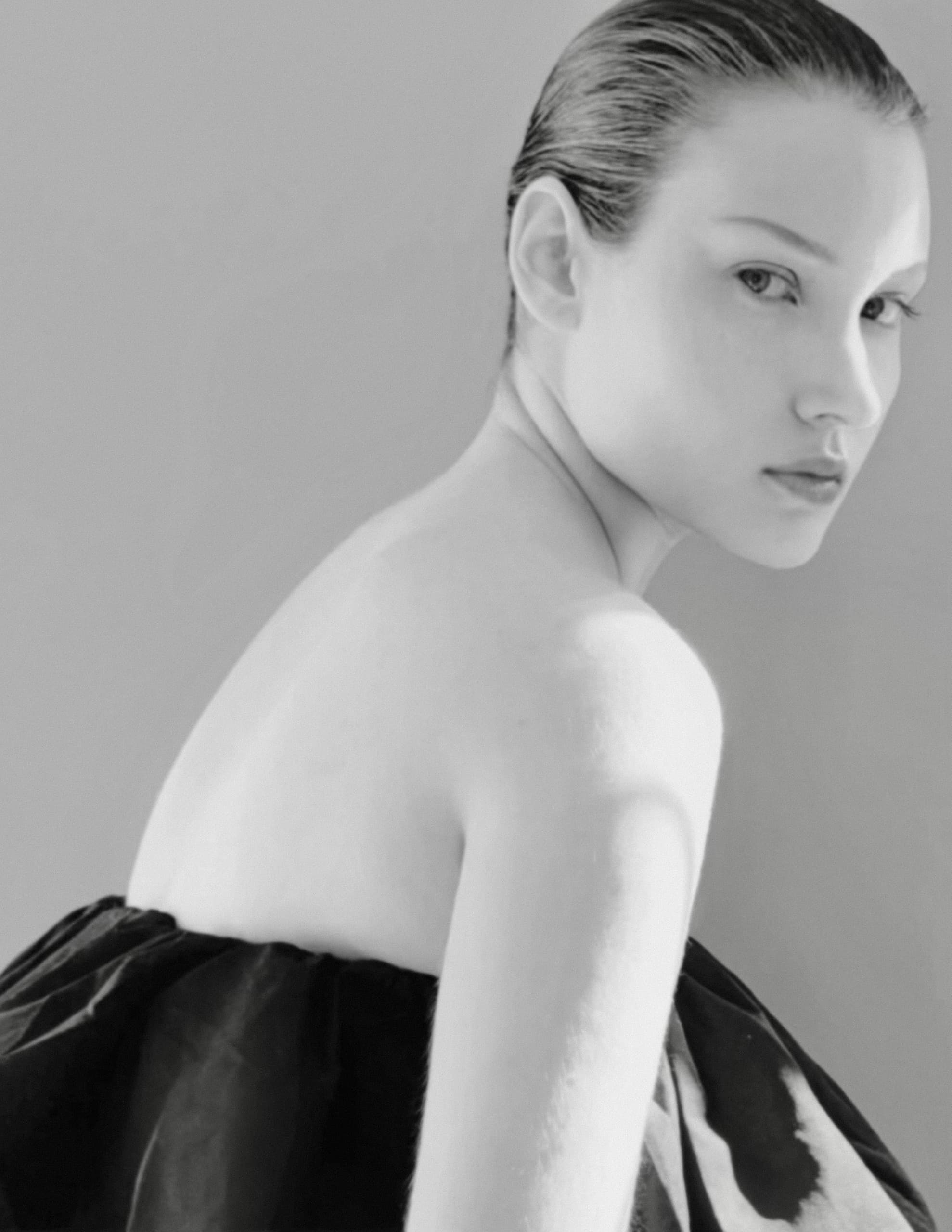 Elegant woman in black and white portrait with stylish, sleek hairstyle.