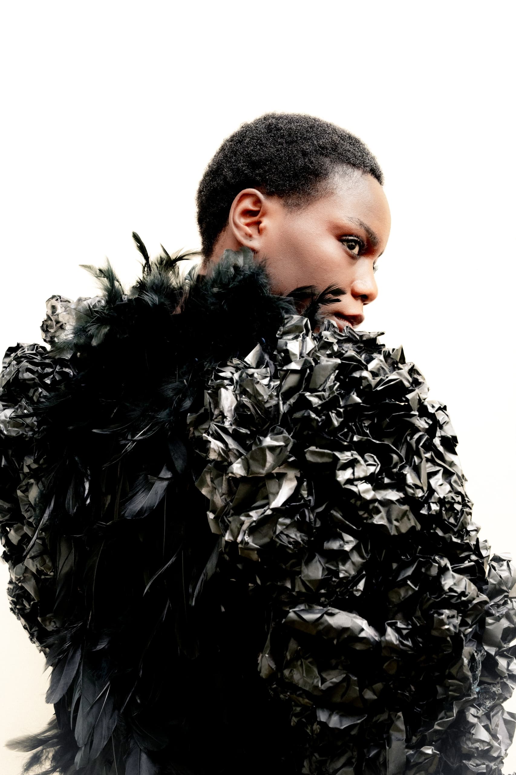 Fashion model in a textured black outfit with feather details.
