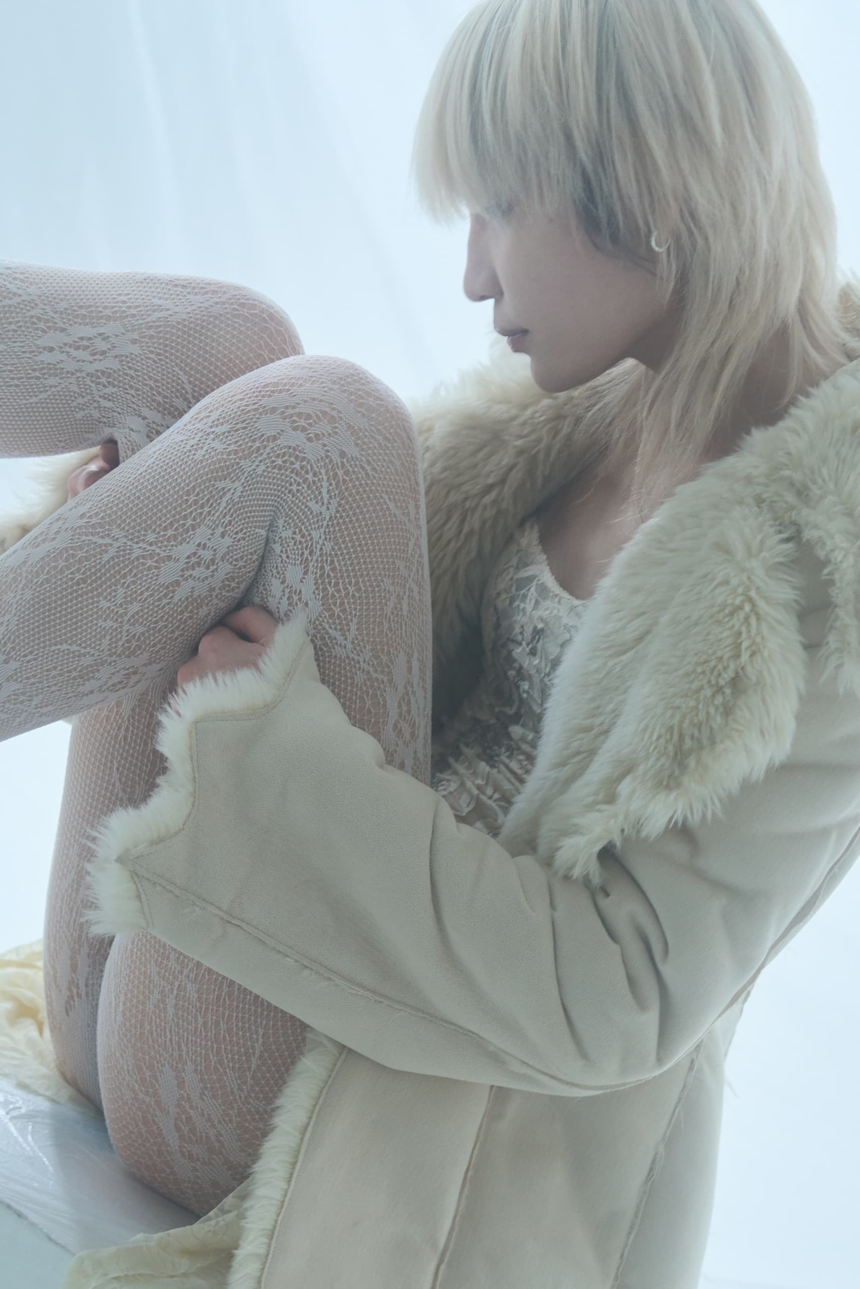 Fashionable person in lace tights and fur coat in soft, dreamy light.