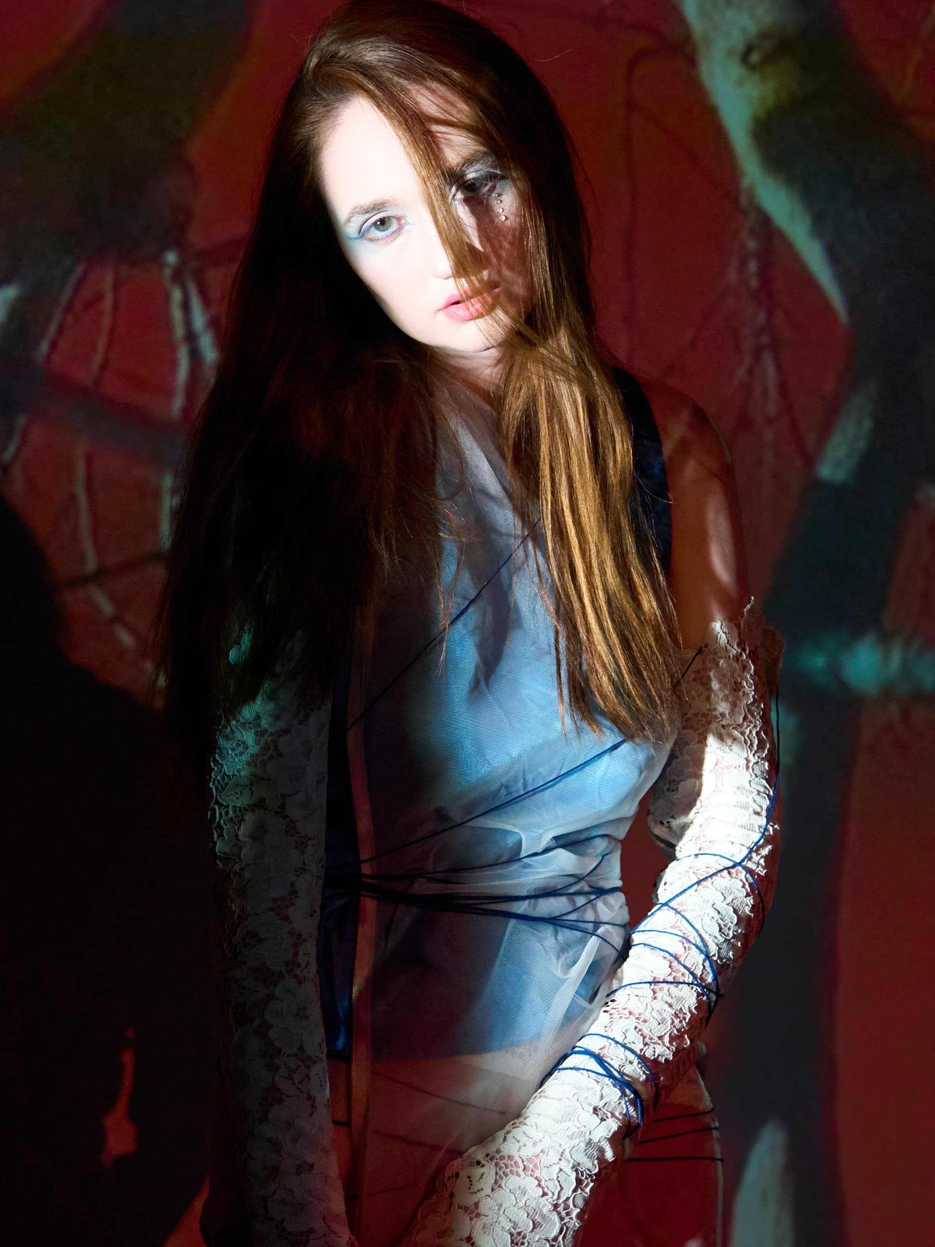 Artistic portrait of woman in lace and blue fabric, ethereal and mystical ambiance.