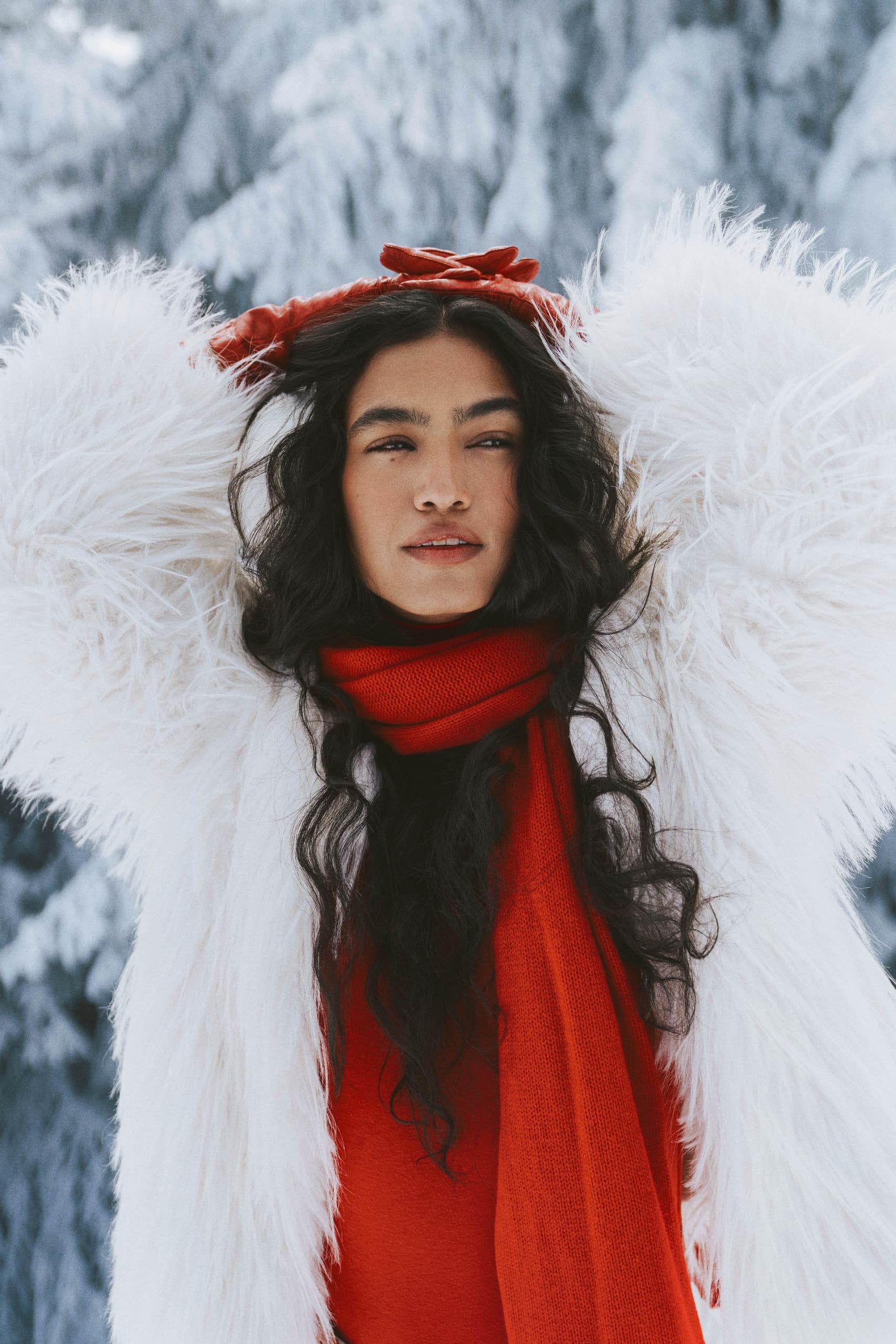 Woman in red and white winter fashion against snowy background.