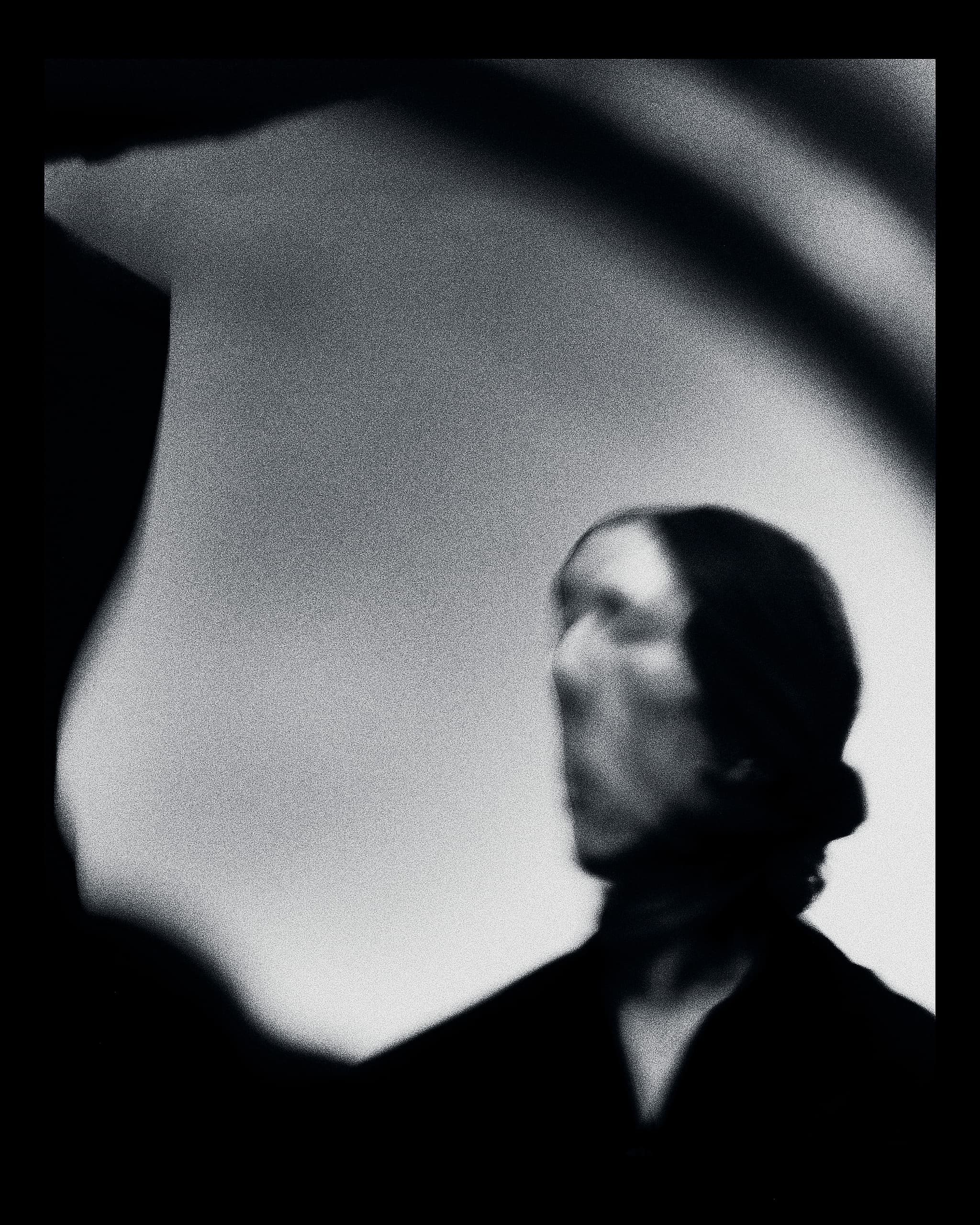 Abstract blurred figure in grayscale, conveying mystery and artistic expression.