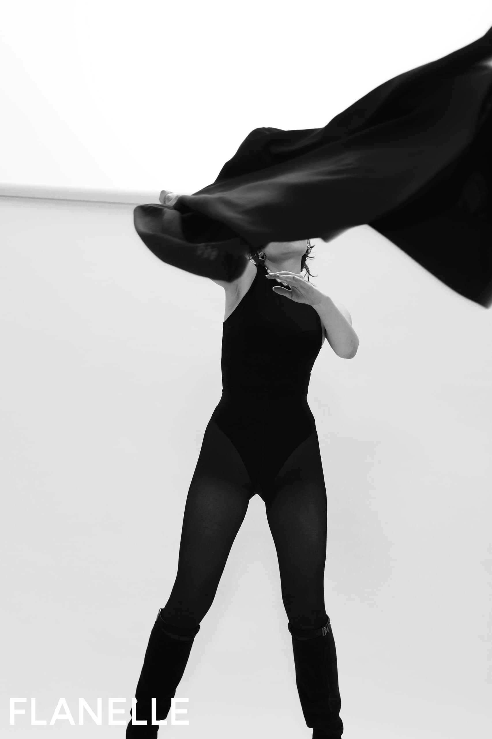 Dancer in black attire with flowing fabric, minimalist fashion, black and white photo.