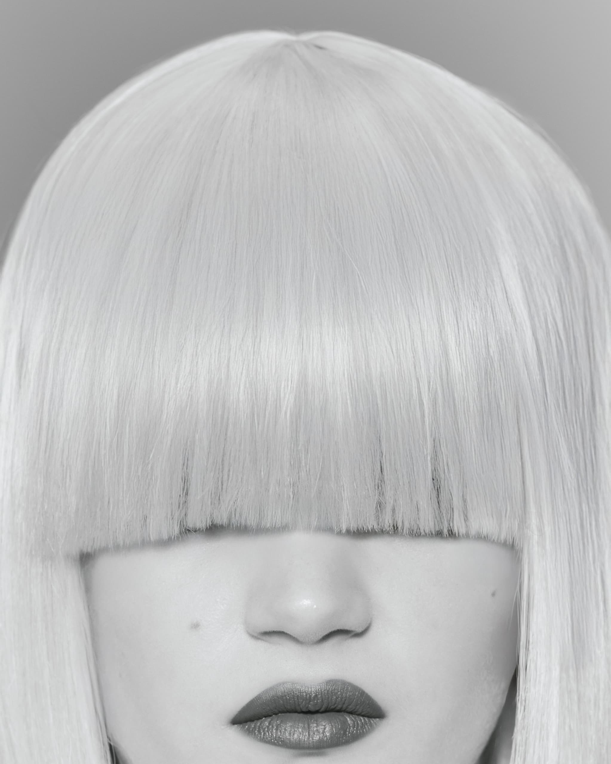 Woman with blunt cut platinum hair and bold lipstick.