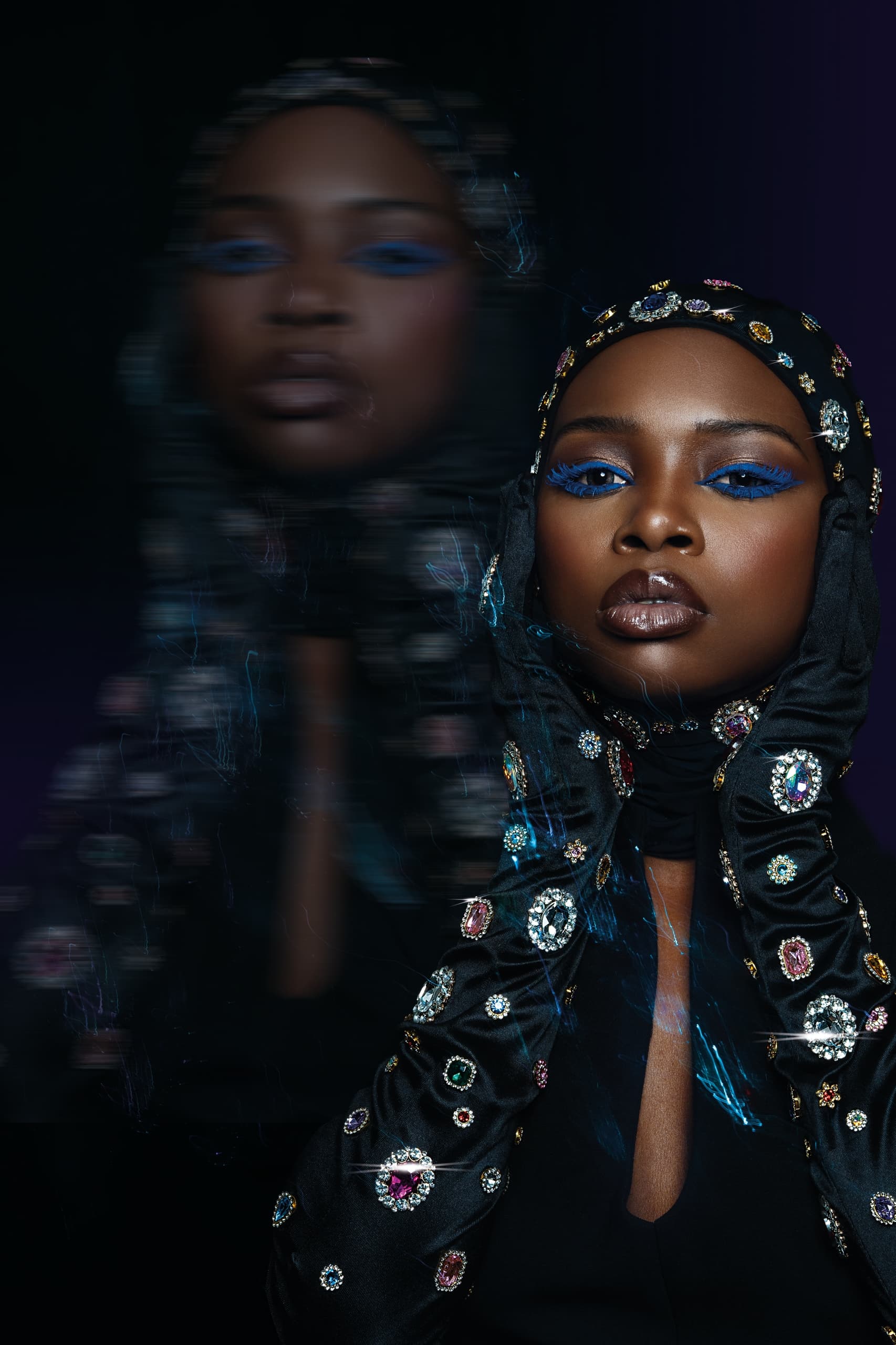 Fashionable woman in jeweled headscarf and bold makeup in artistic portrait.
