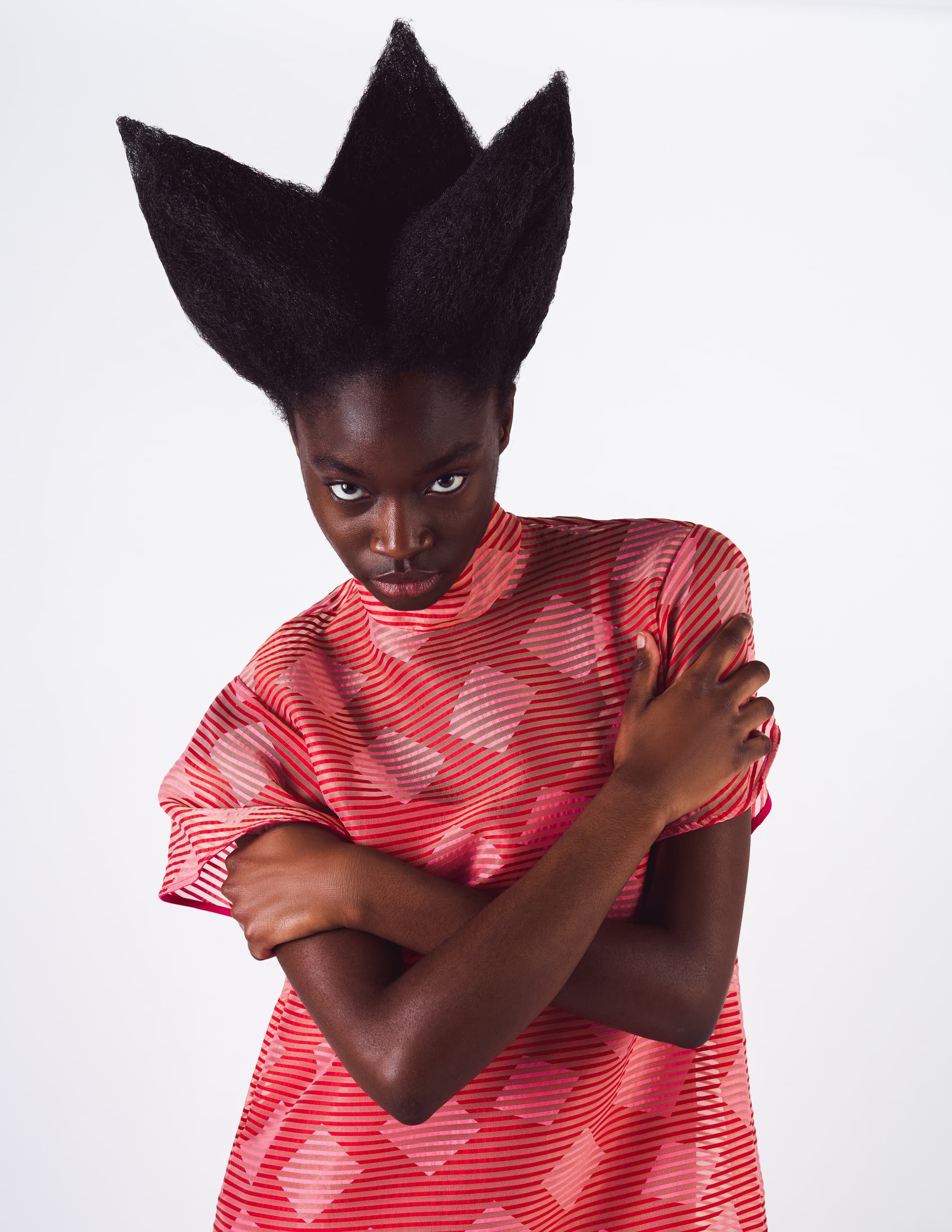 Unique hairstyle and geometric-patterned dress fashion.