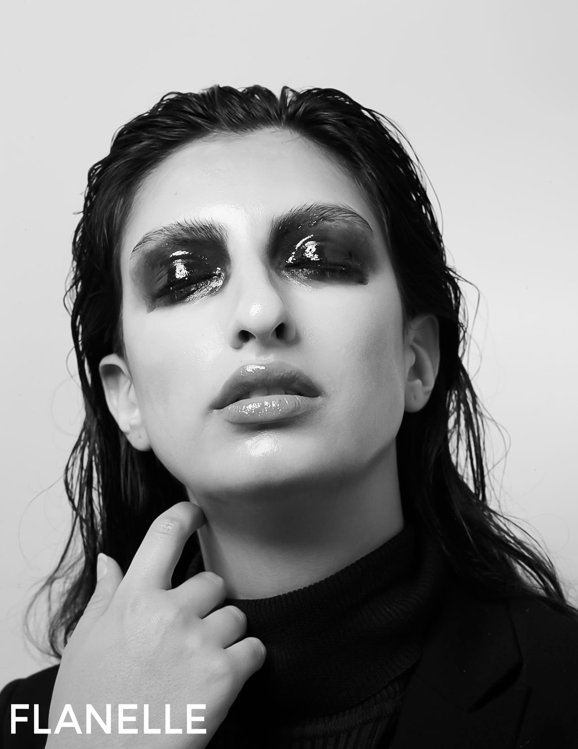 Fashion portrait of a person with smoky eye makeup and glossy lips.