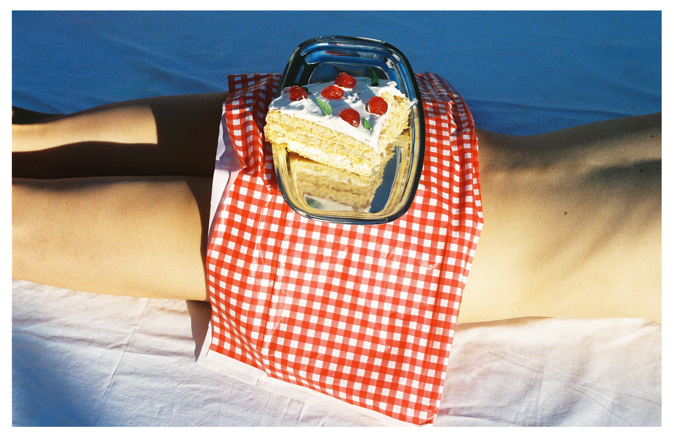 Cake on checkered cloth with sunlight and shadow contrast.