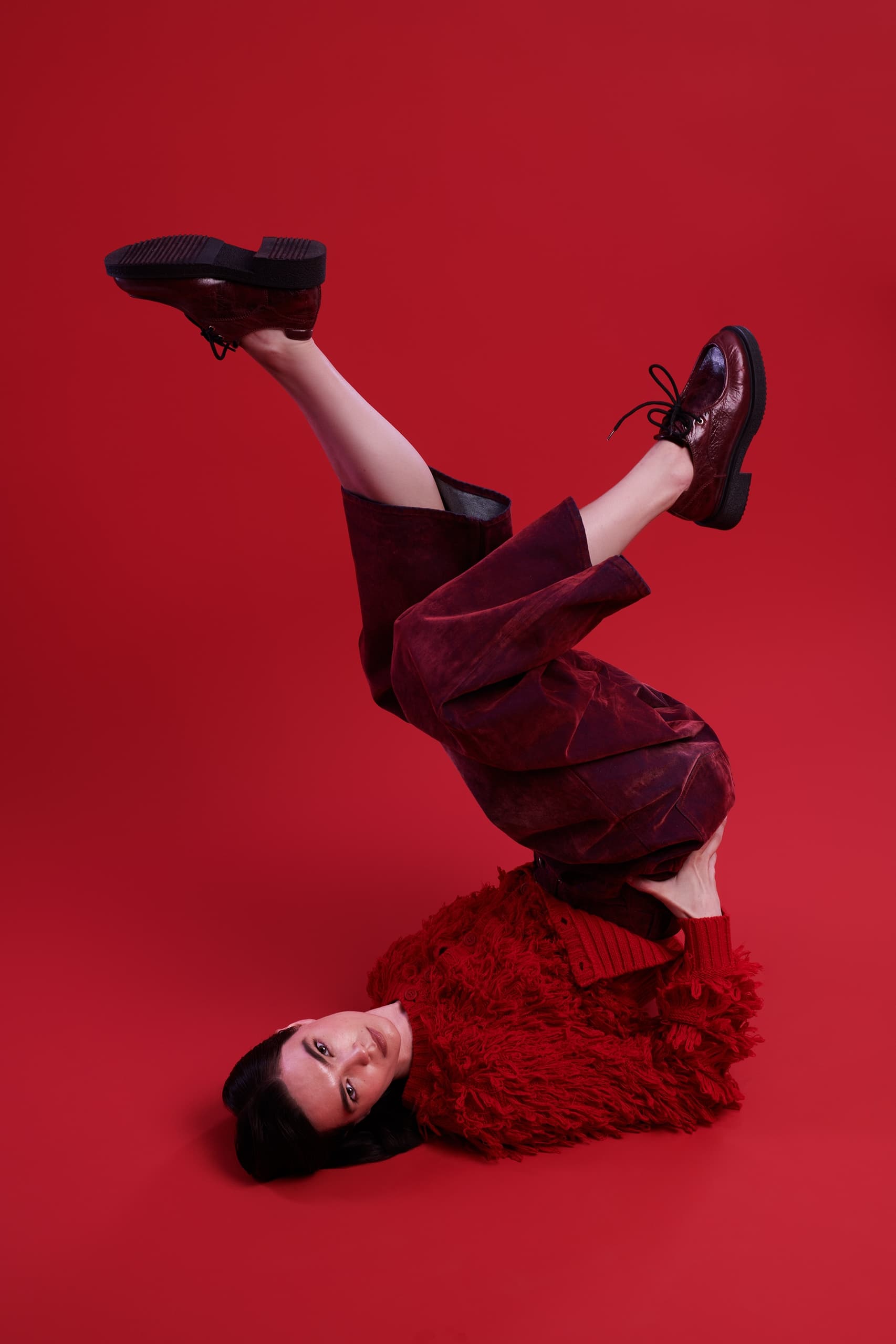 Fashion statement: woman in vibrant red outfit and shoes on red background.