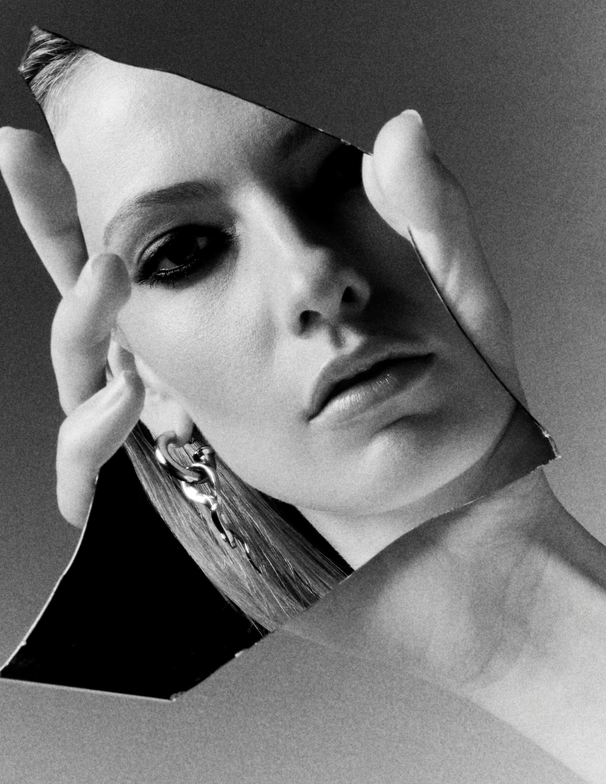 Artistic black and white photo of a woman with a mirrored reflection.