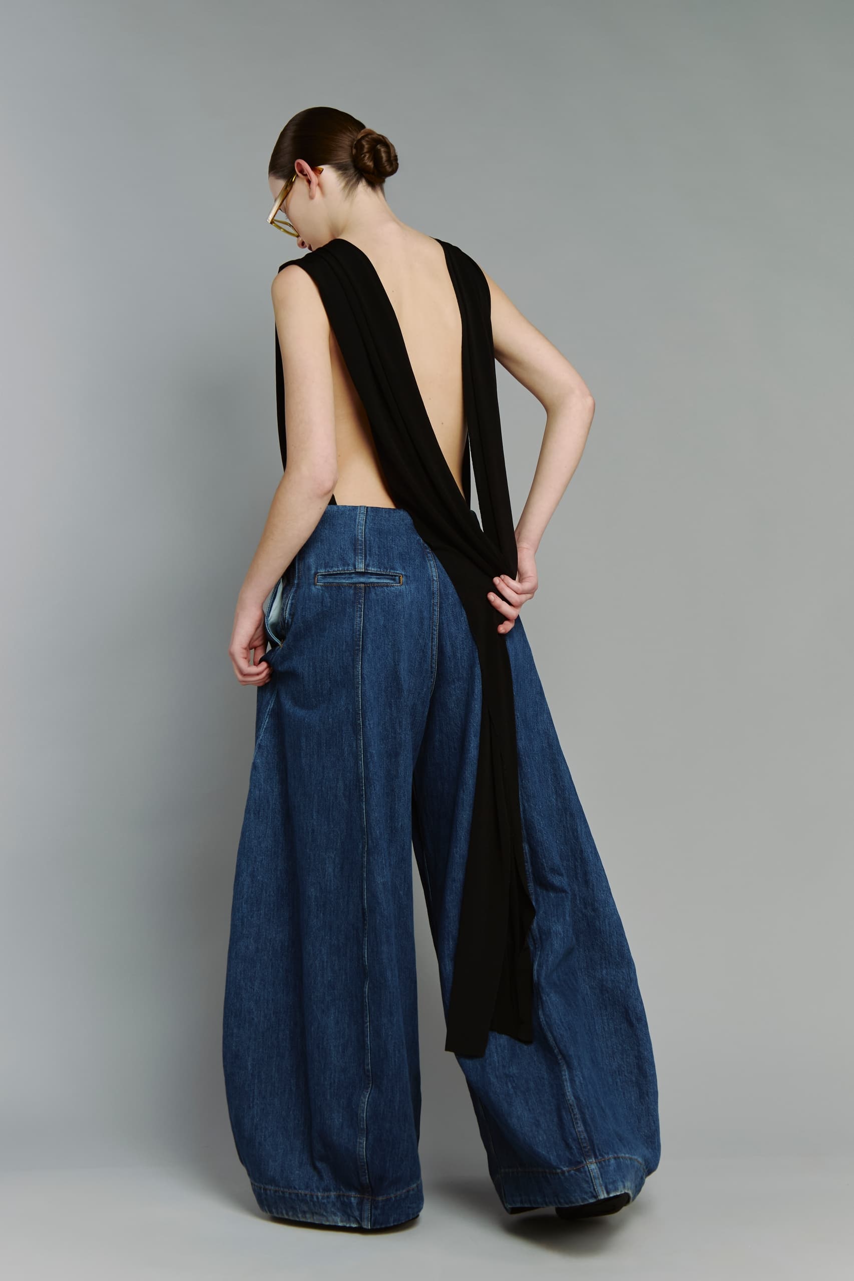 Stylish backless top with wide-leg jeans fashion photo.