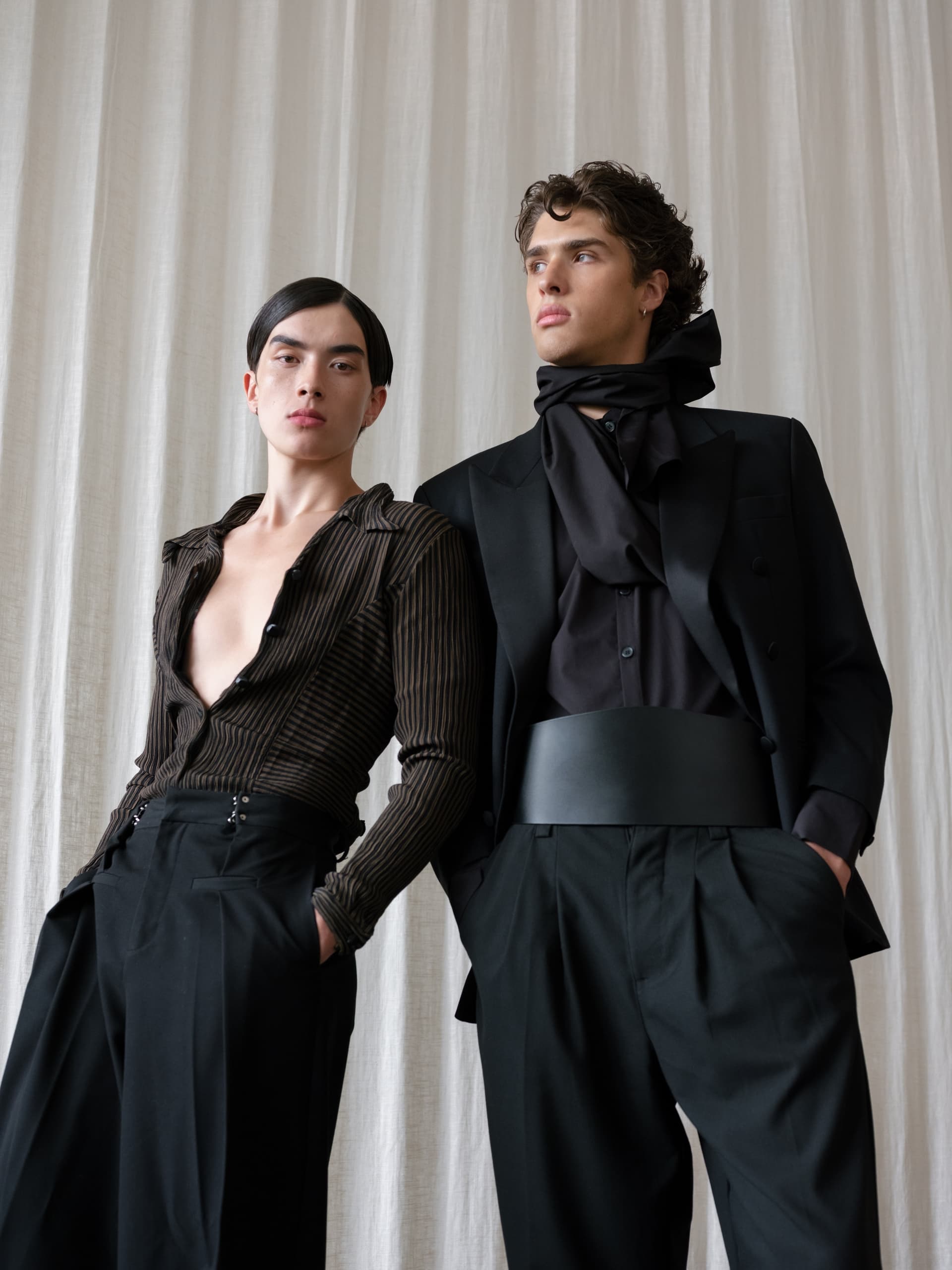 Fashion models in elegant black and brown attire, posing with confidence.