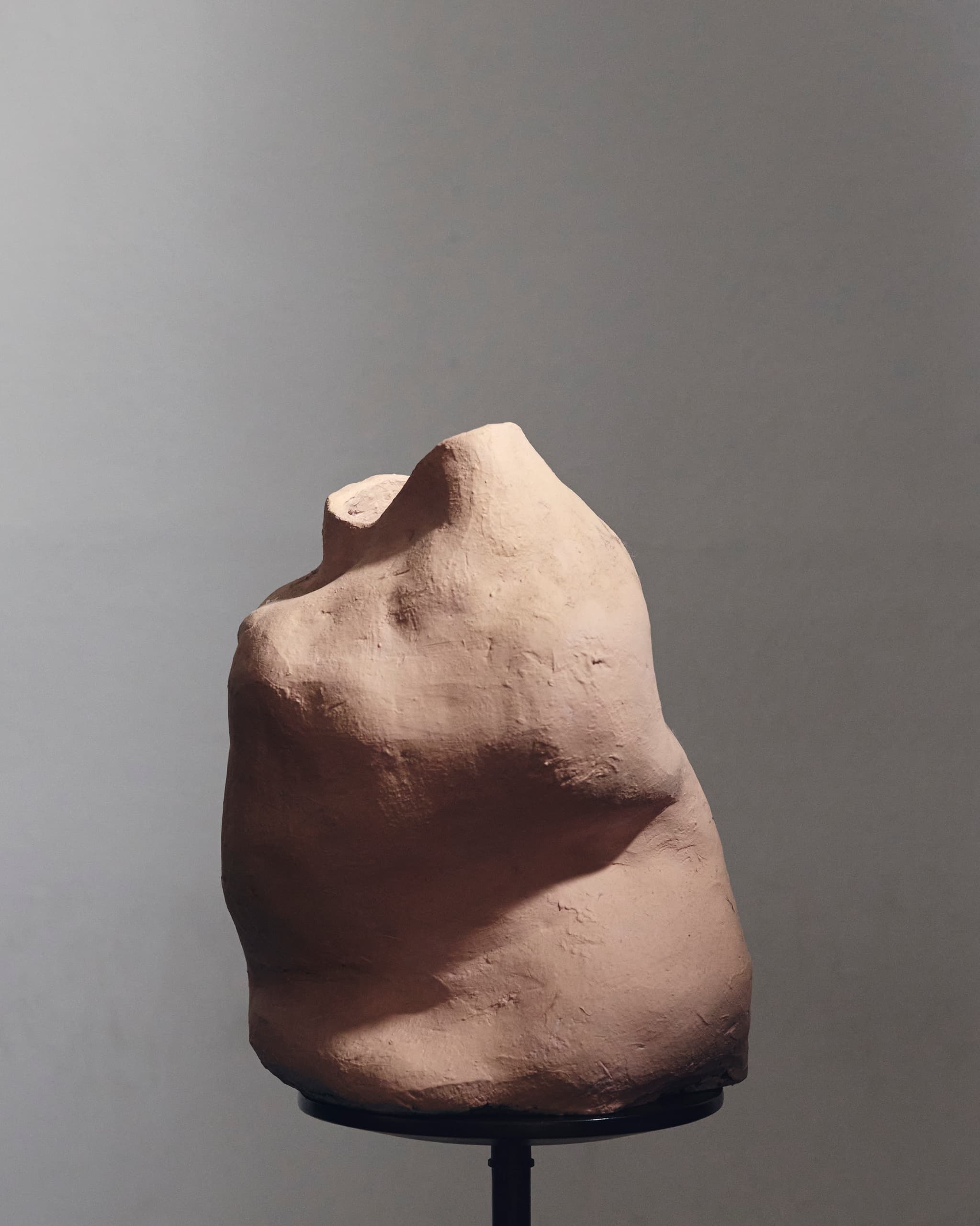 Clay sculpture on display against a plain background.