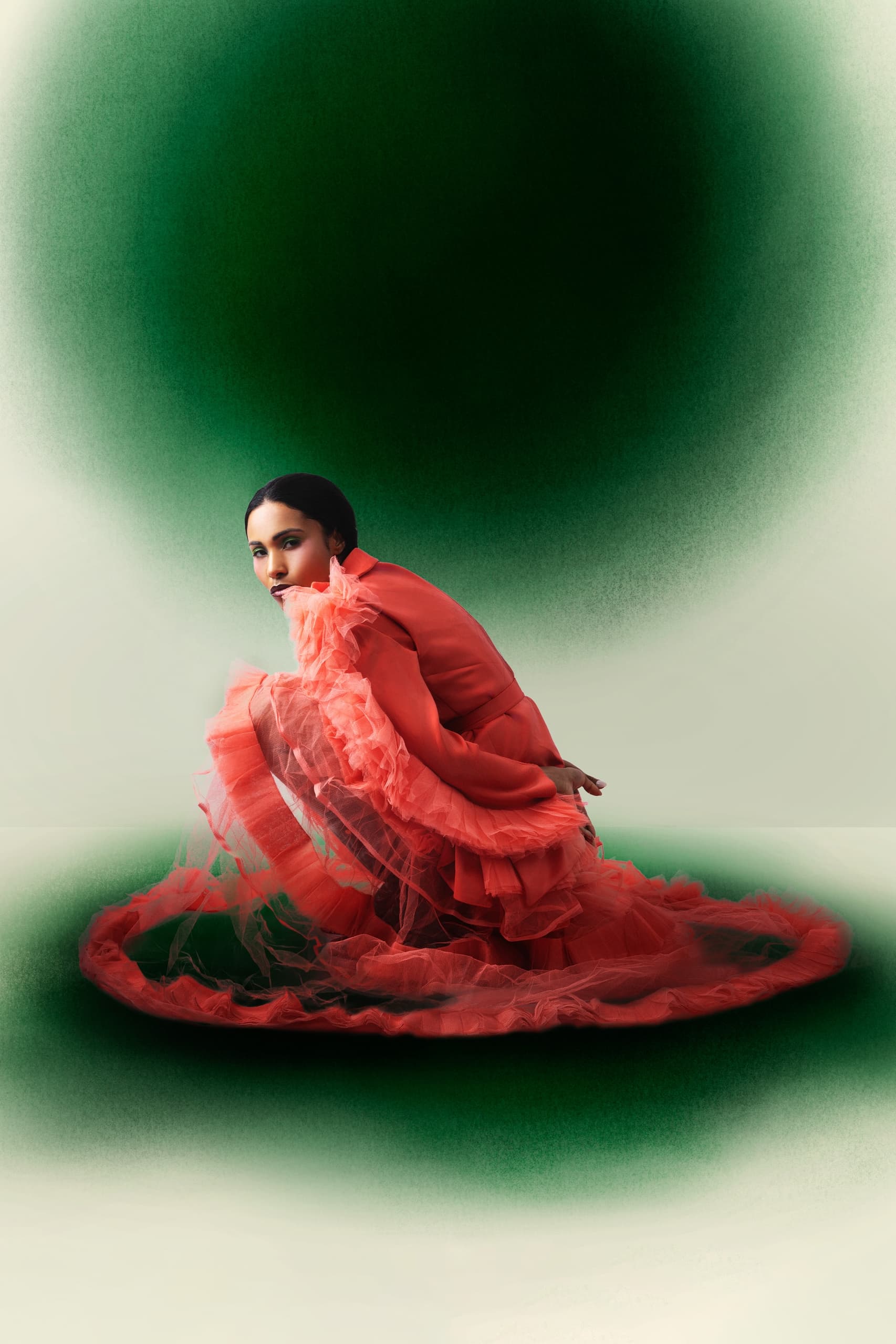 Woman in red tulle dress, crouching, vibrant green background, artistic fashion shot.