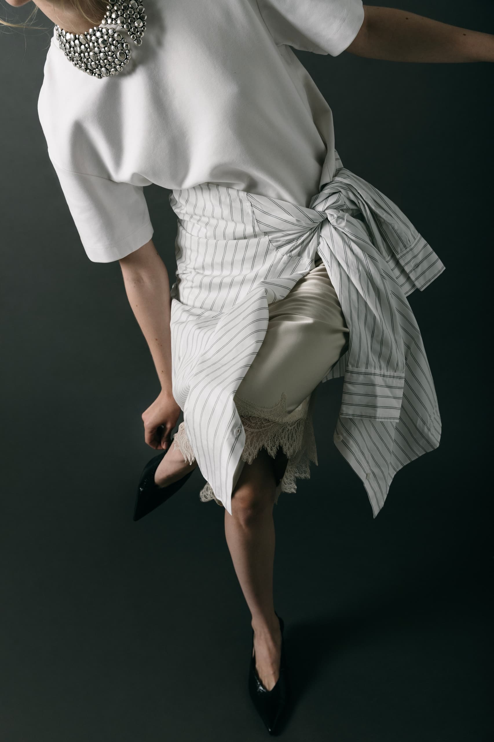 Fashionable woman in stylish layered outfit with elegant accessories.
