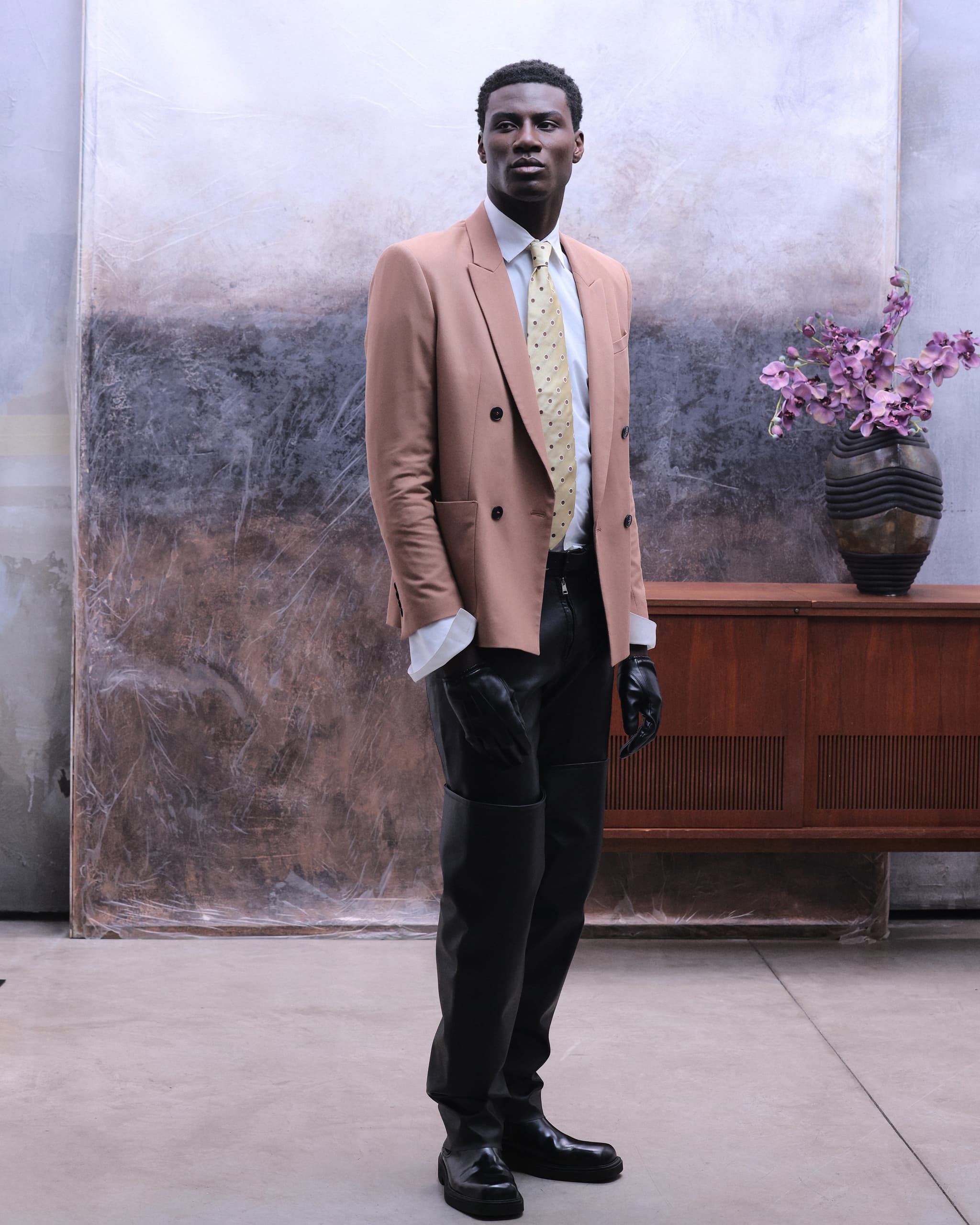 Stylish man in modern suit posing indoors with elegant decor.
