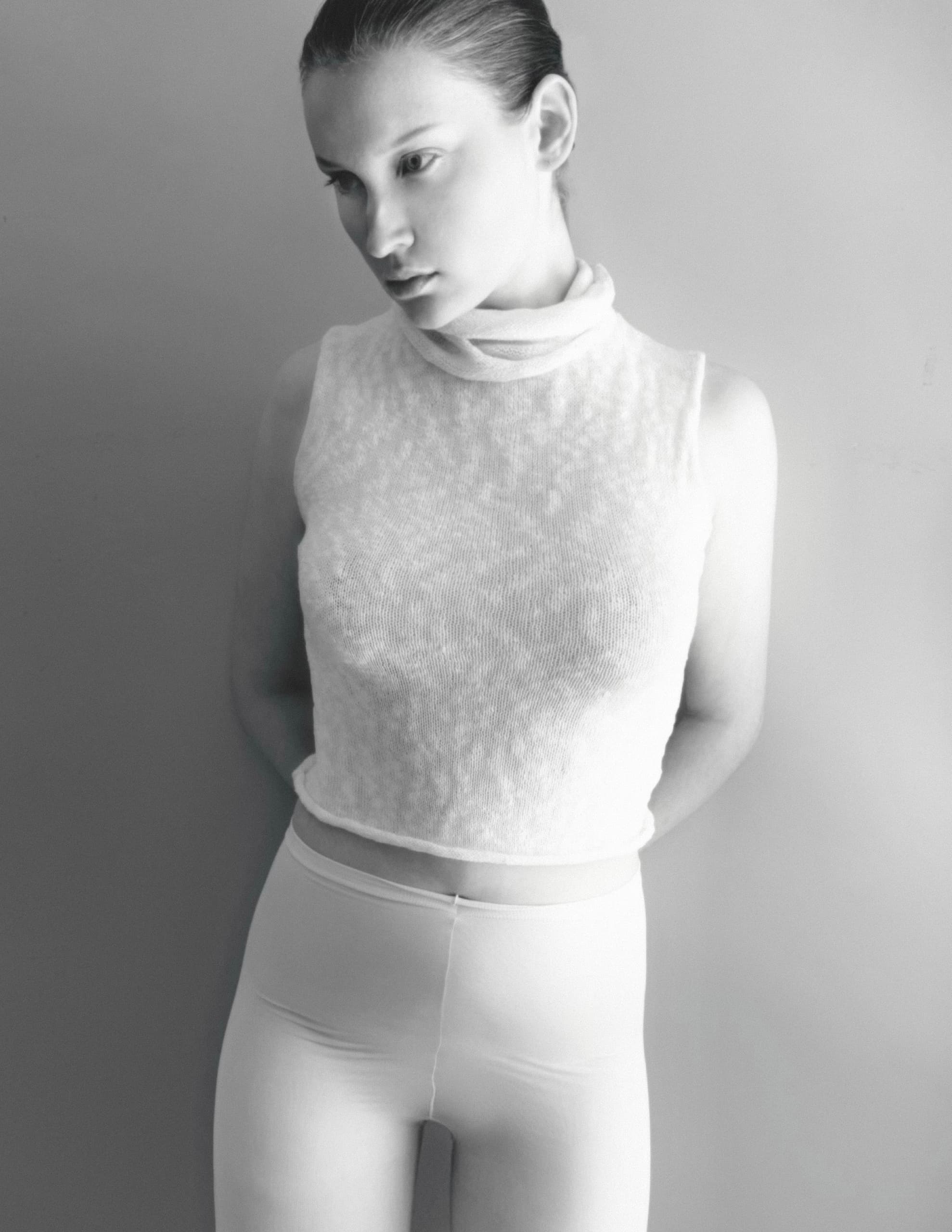 Black and white portrait of a woman in a sleeveless top, facing sideways.