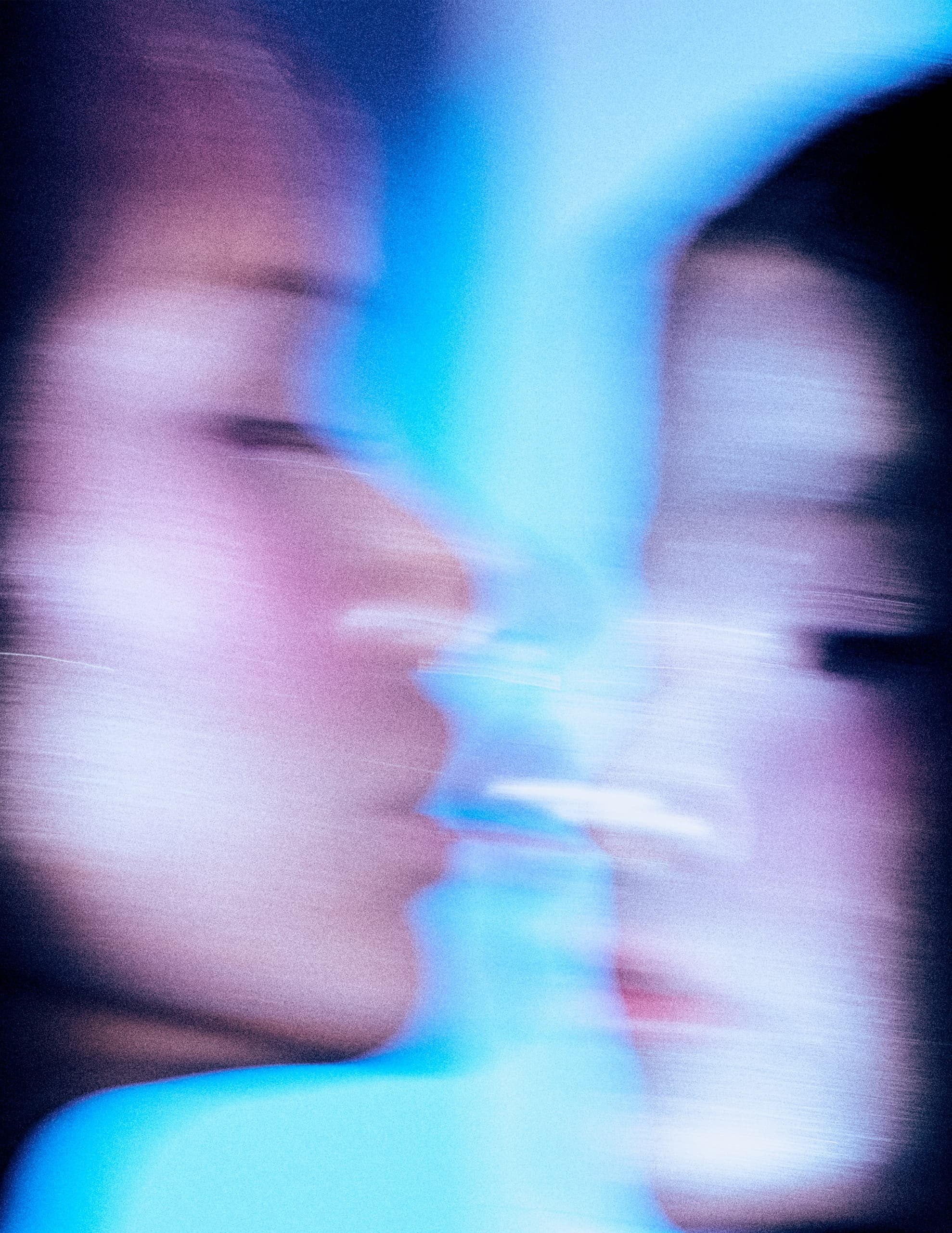 Abstract blurred profiles against a blue background, capturing motion and emotion.