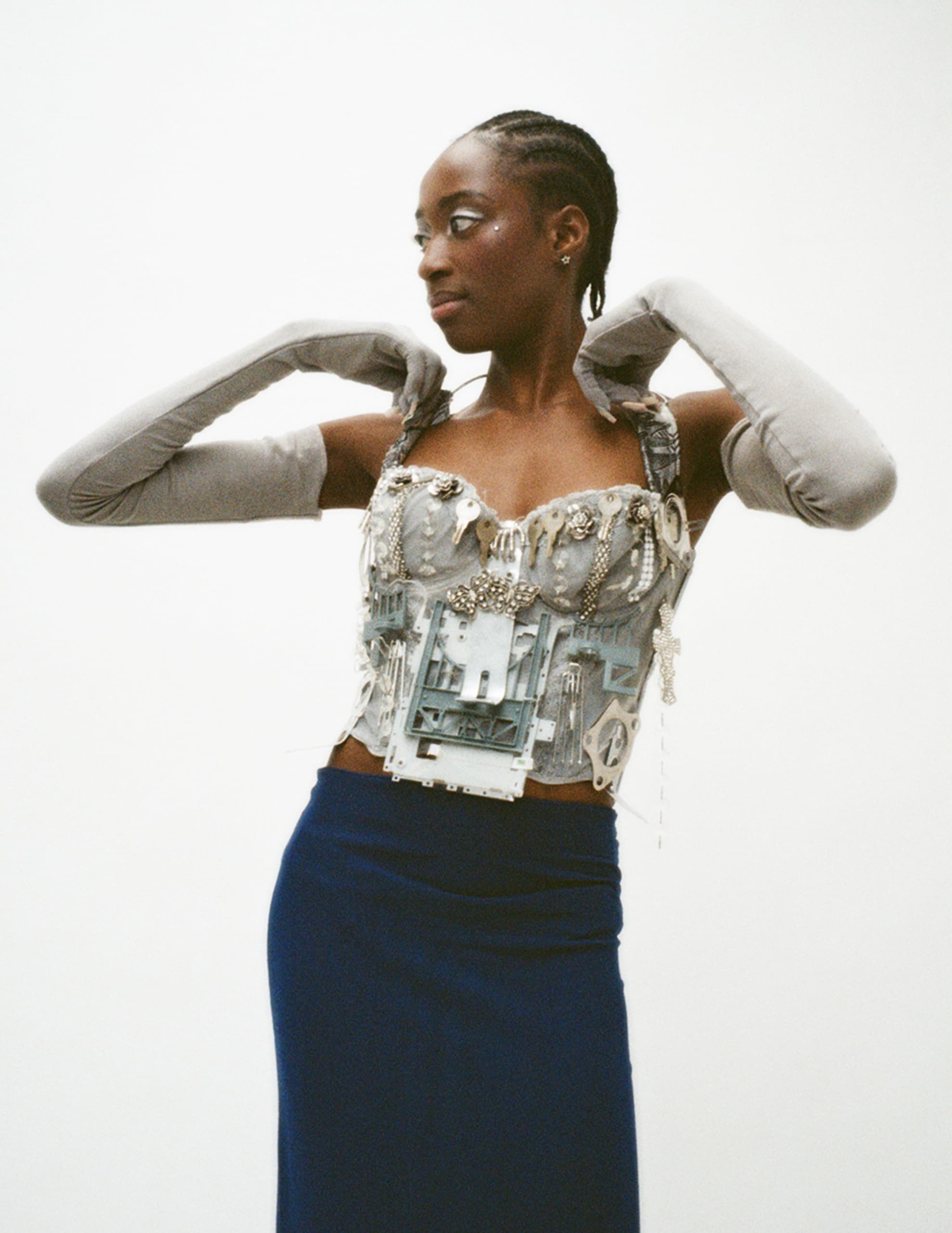 Woman in ornate corset and gloves, fashionable artwear.