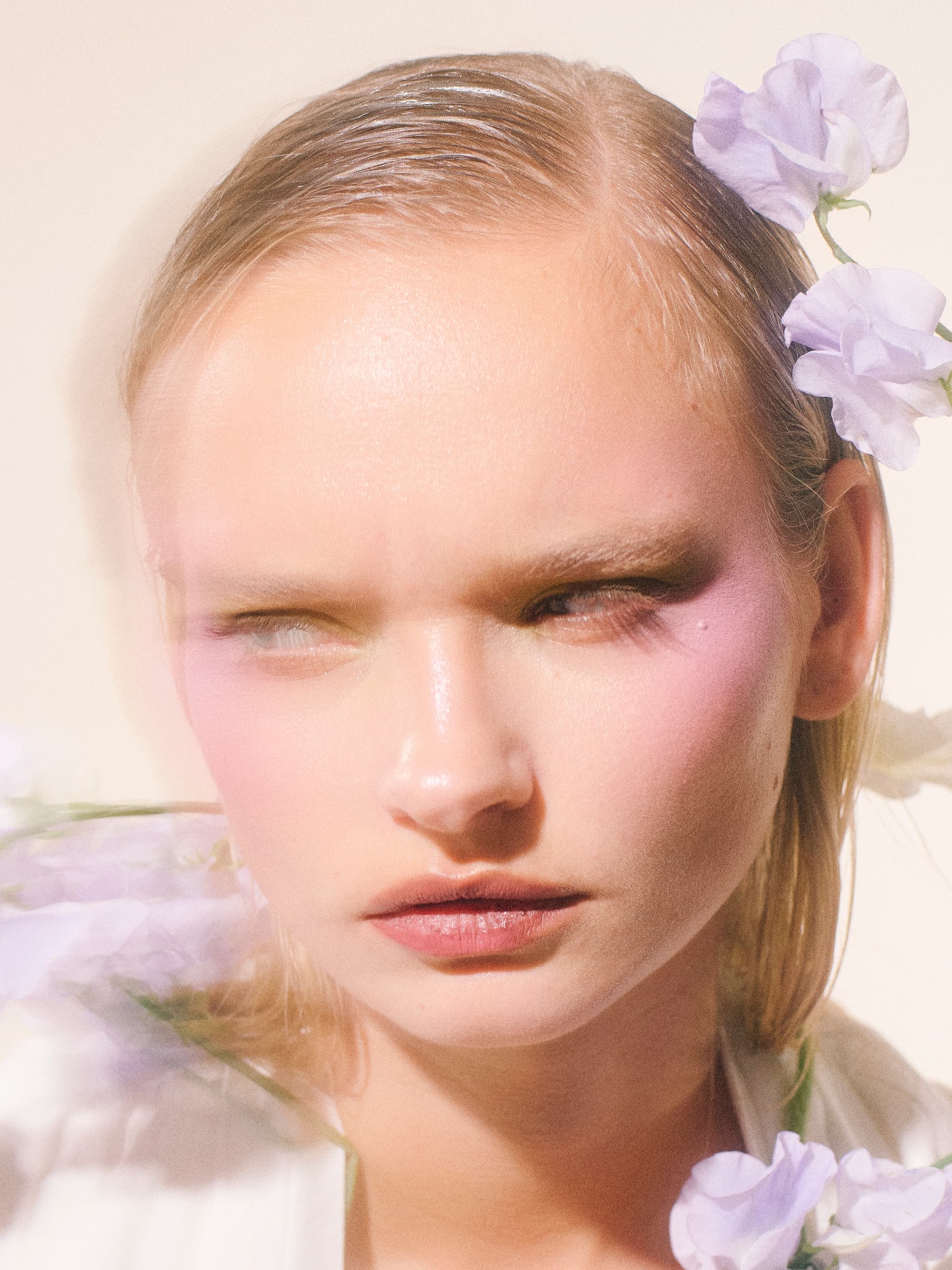 Elegant woman with lilac flowers and soft makeup.