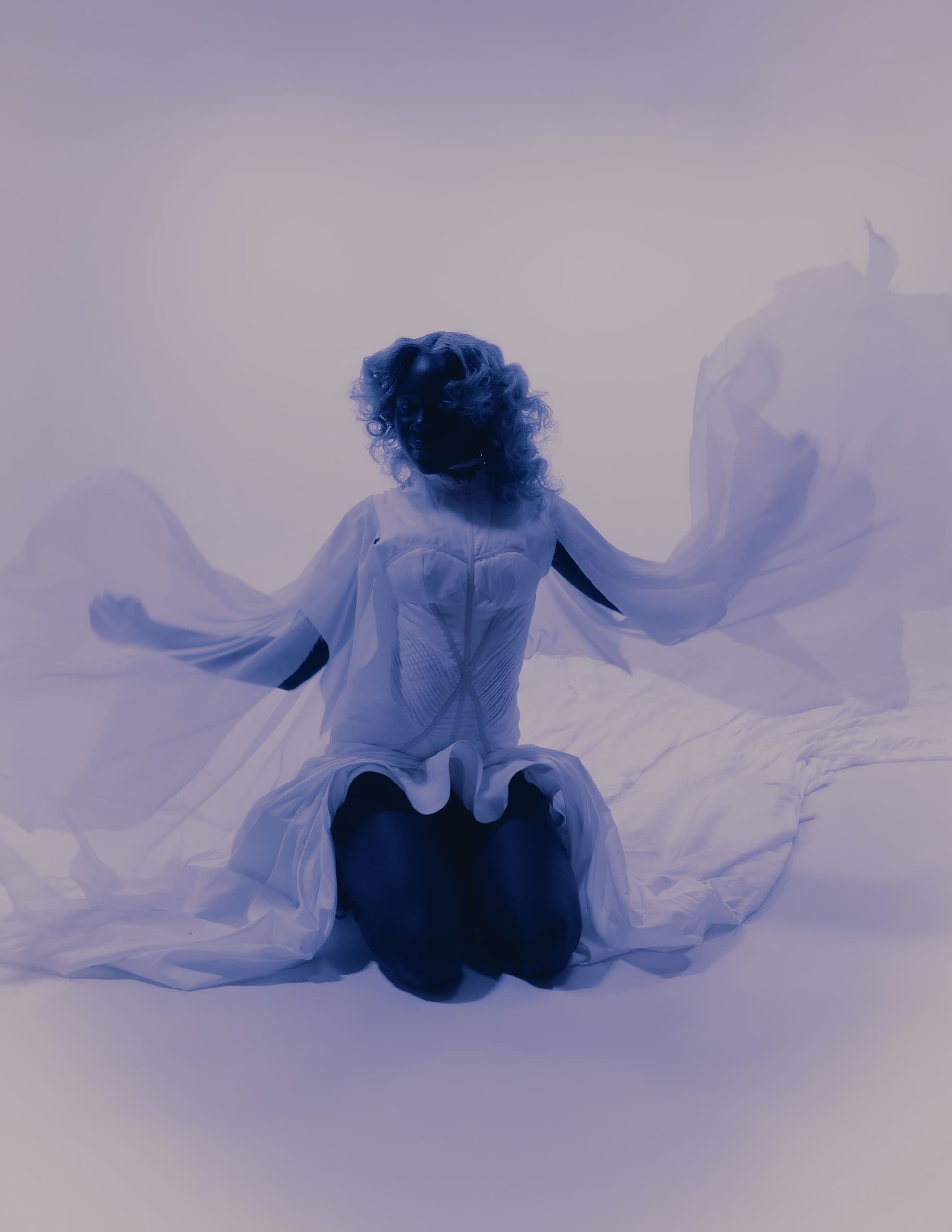 Silhouette of person in flowing dress with ethereal, dreamlike lighting.