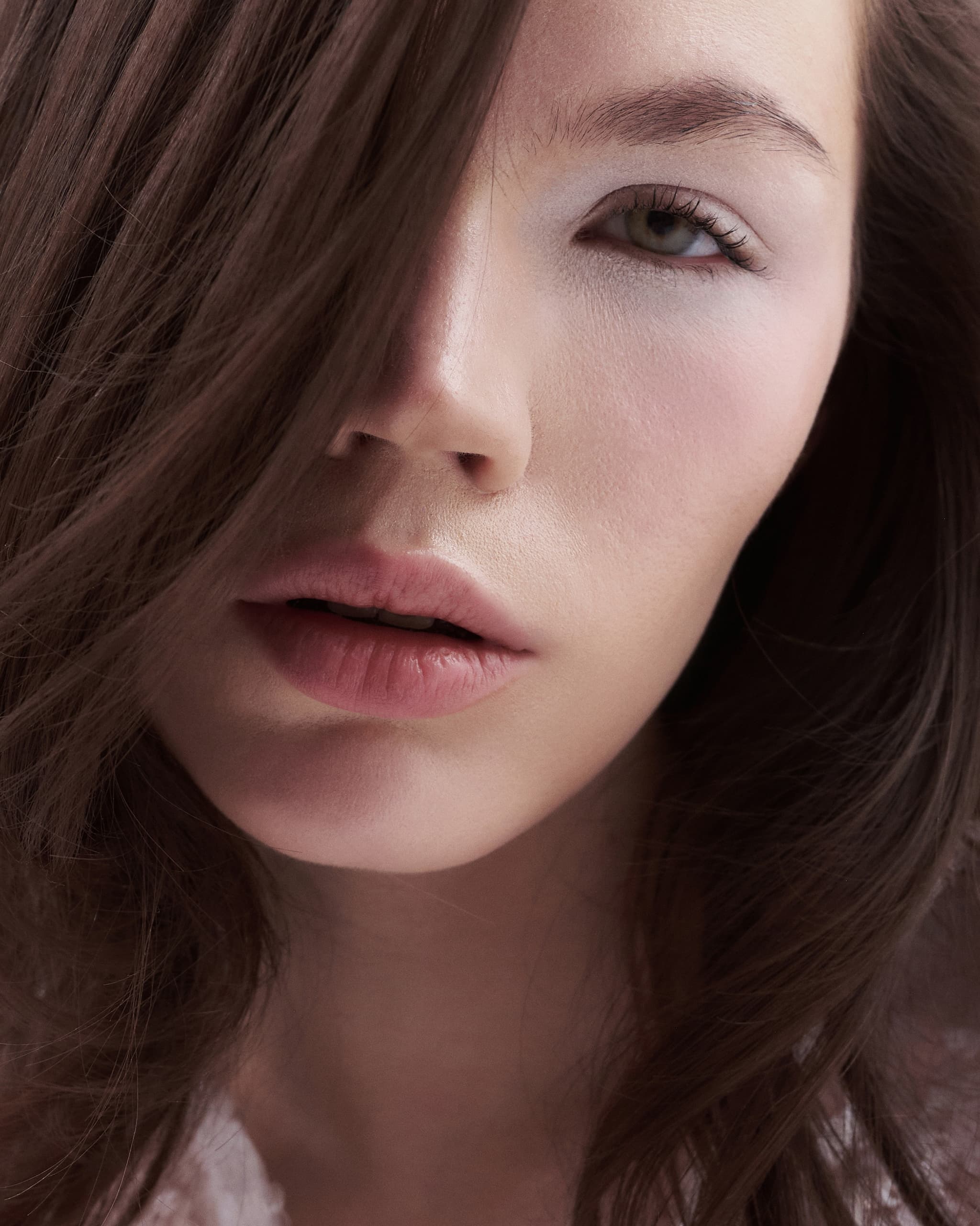Close-up of a woman with long hair and natural makeup.