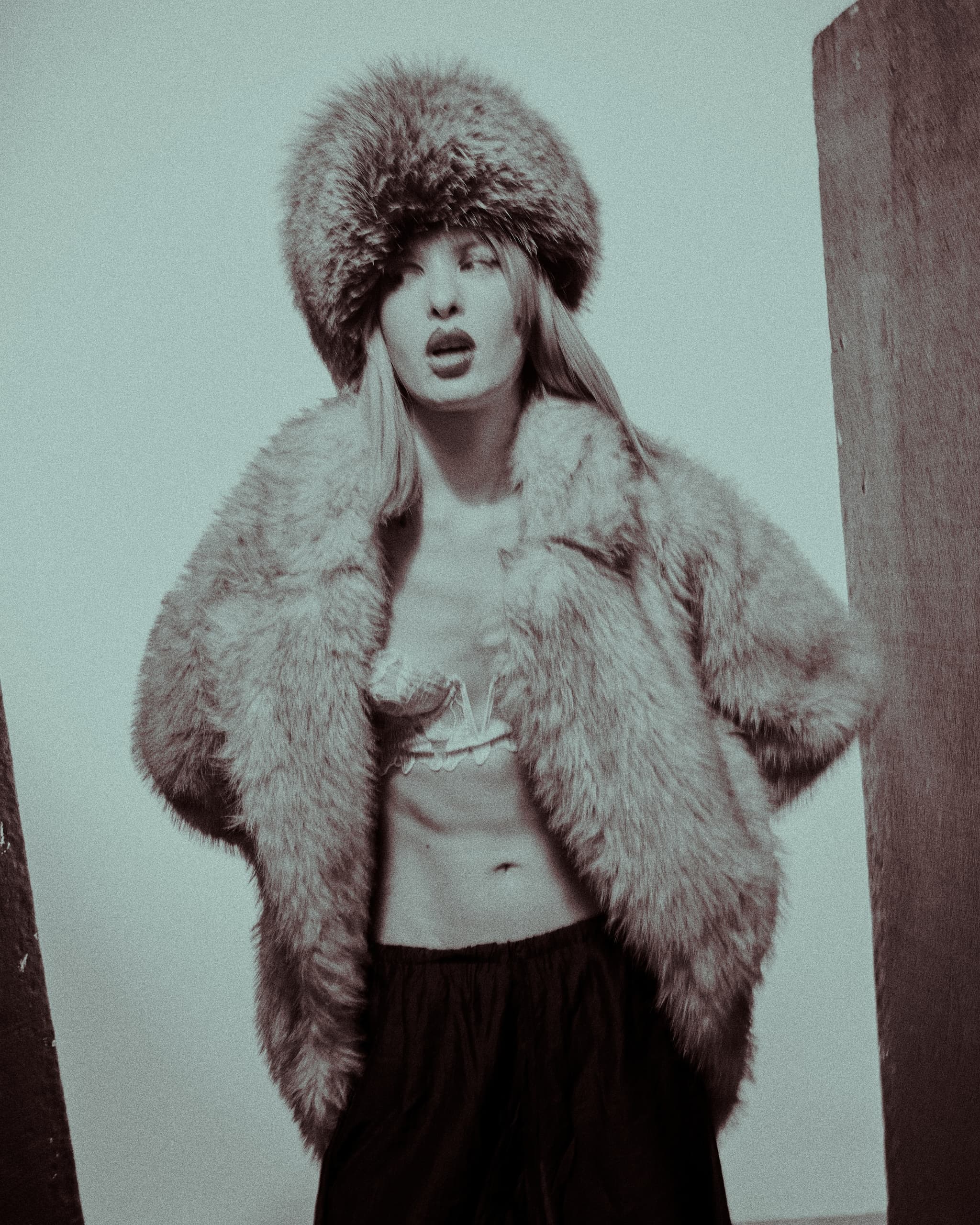 Person wearing a stylish fur coat and hat, exuding vintage fashion elegance.