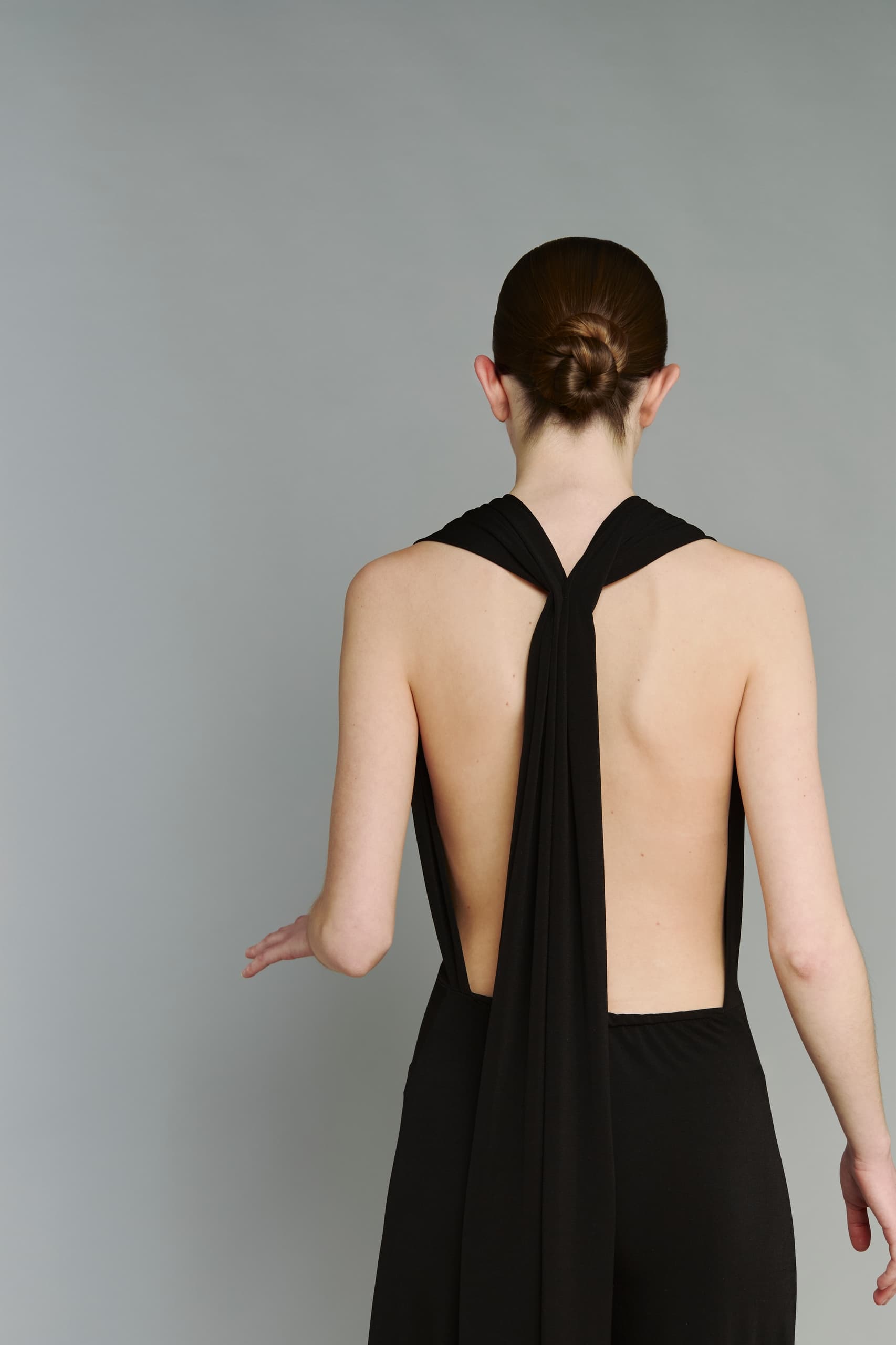 Woman in black backless dress with elegant updo hairstyle.