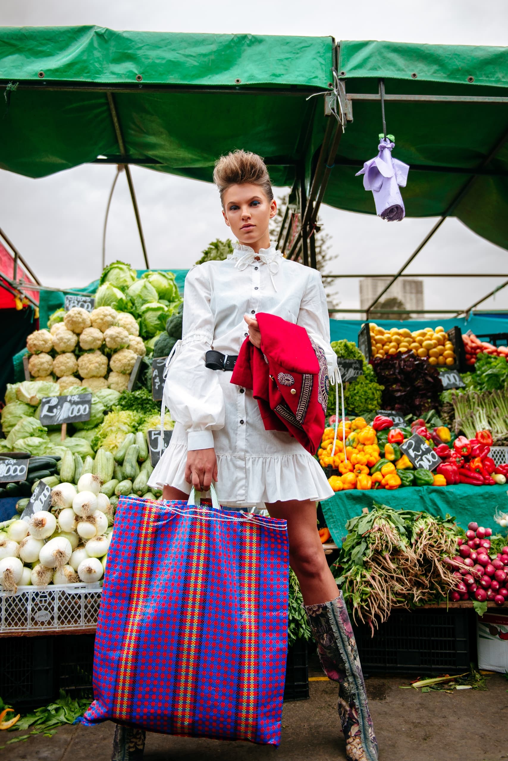 Fashionable woman shopping at colorful vegetable market.