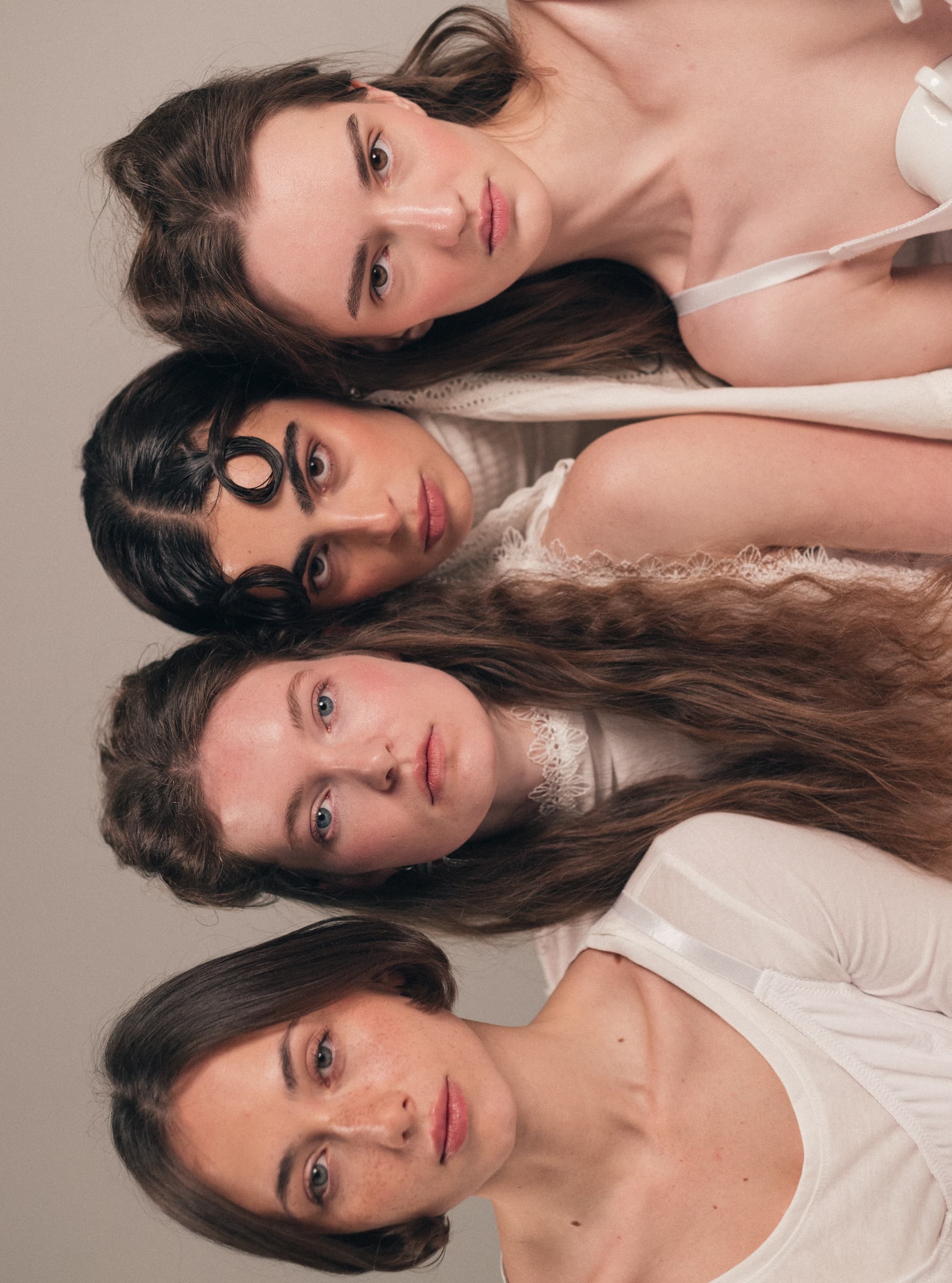Four women stacked vertically, each with unique hairstyles and serene expressions.