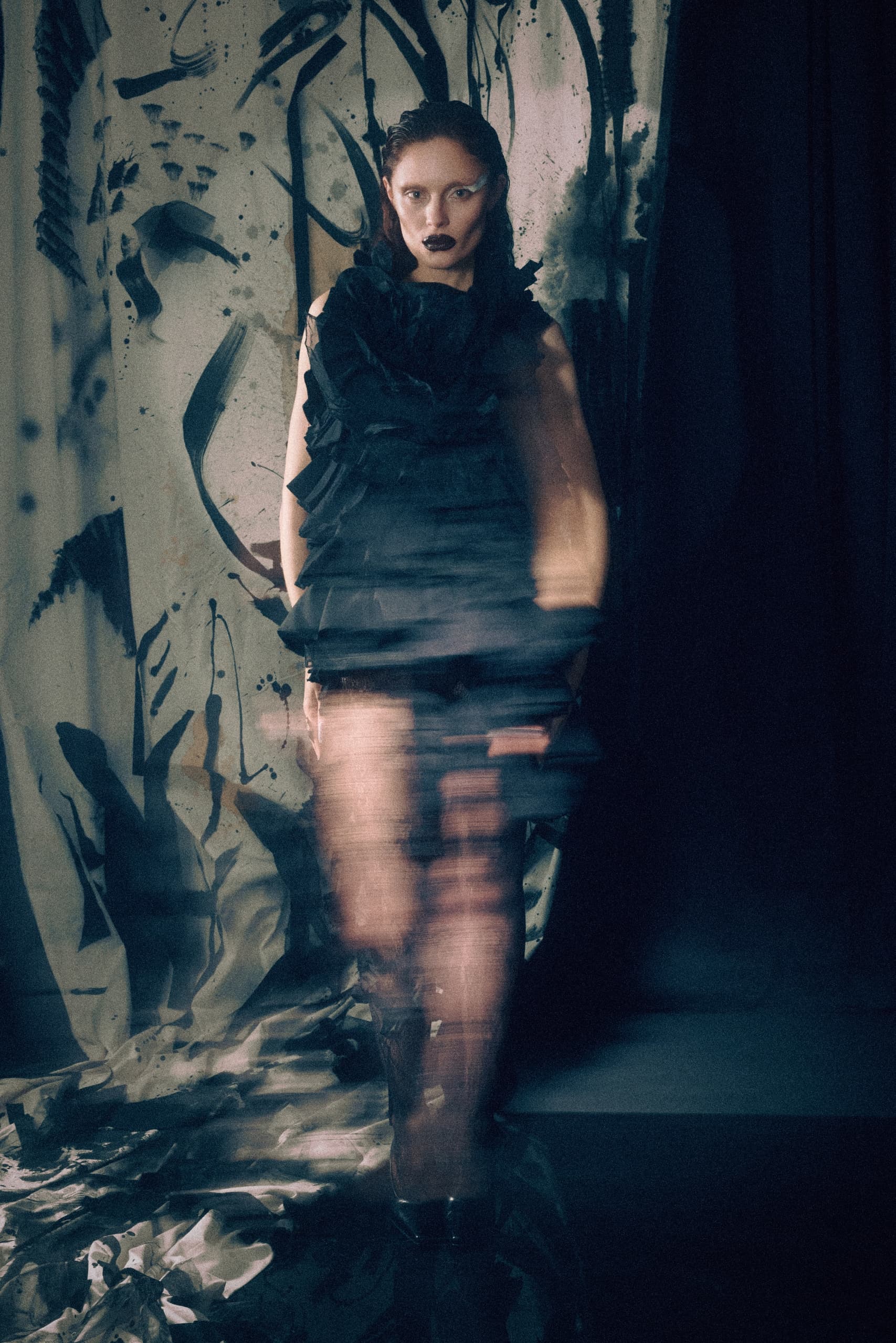 Artistic fashion model in abstract black dress, blurred effect.