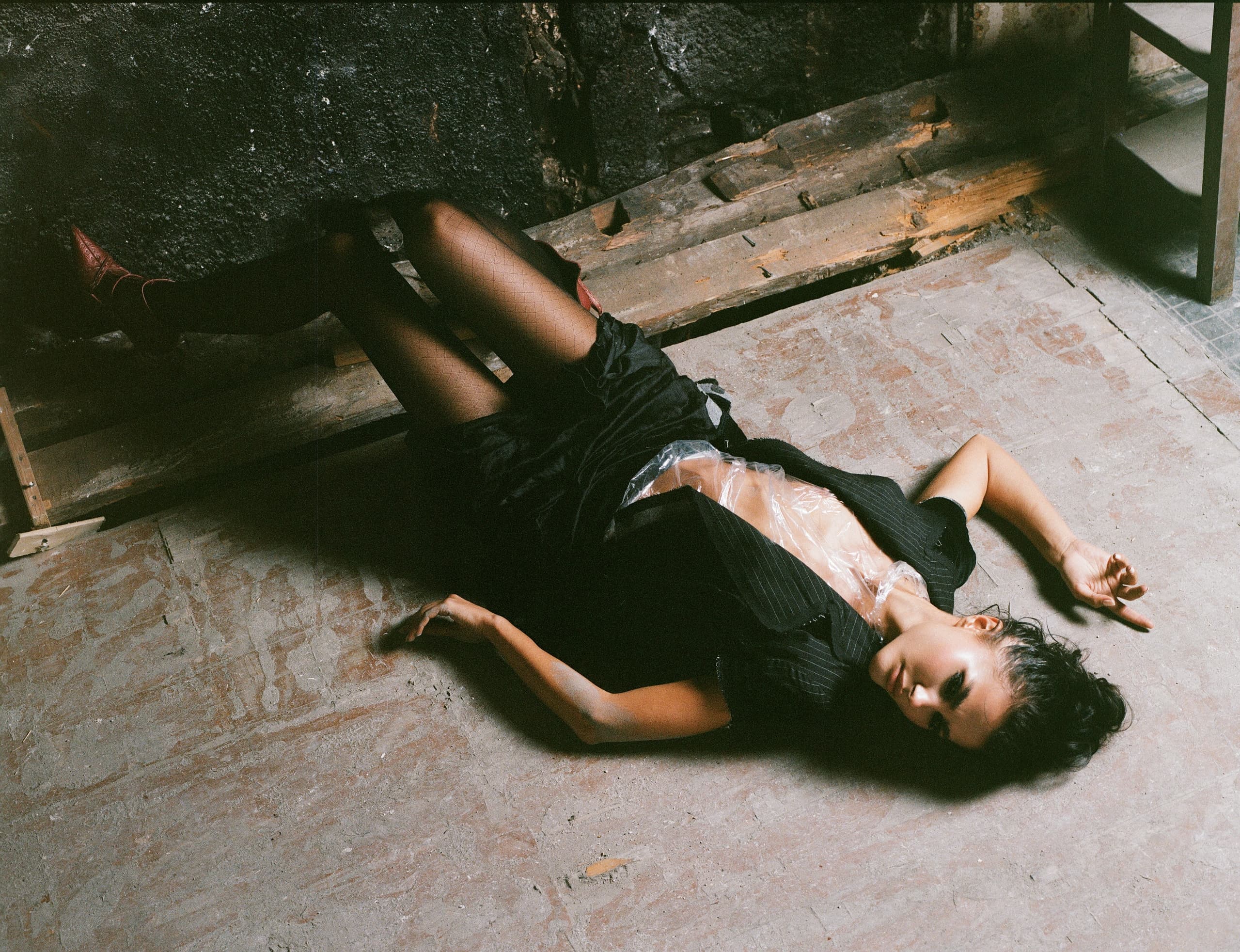 Fashionable woman posing on industrial floor in creative, edgy outfit.