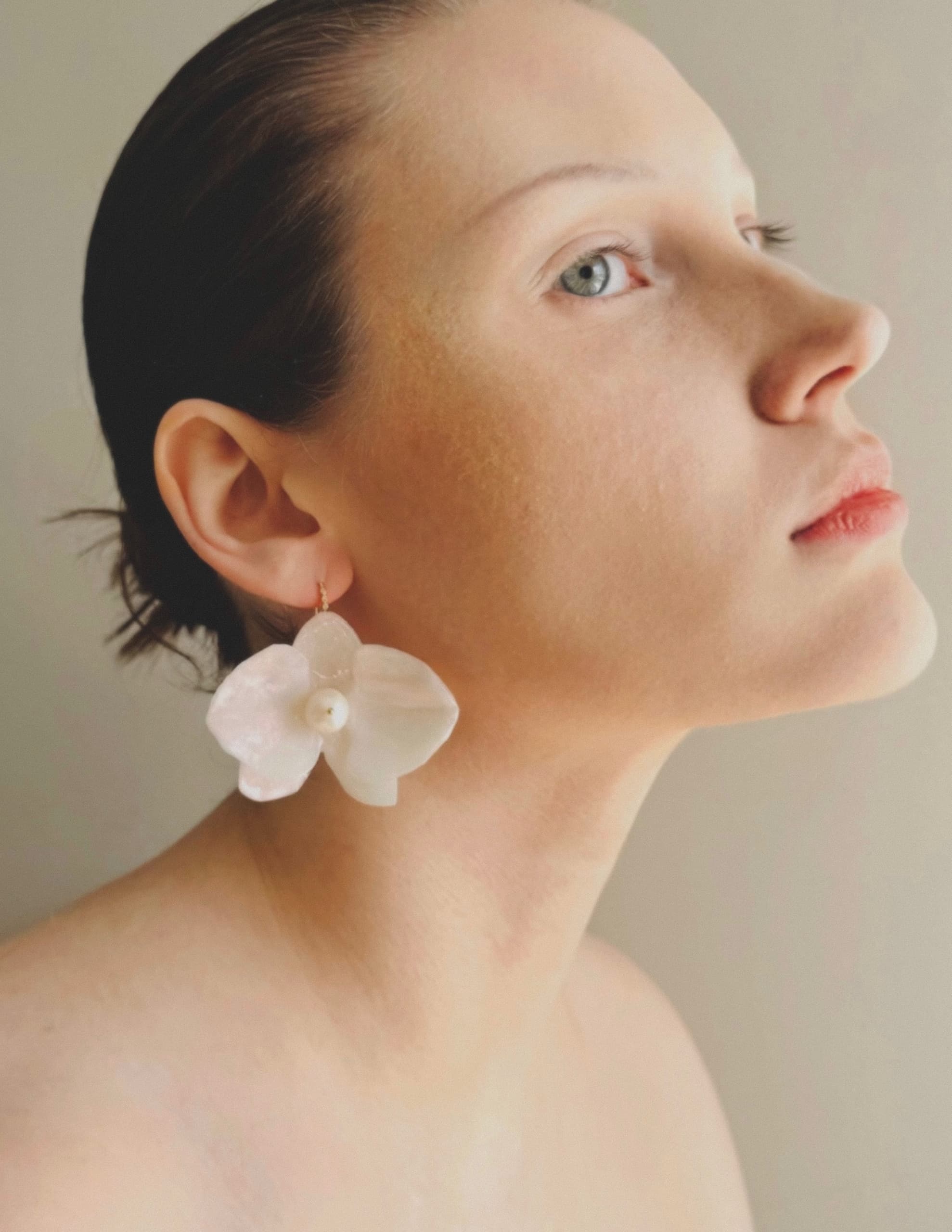 Profile view with elegant flower earring on woman.