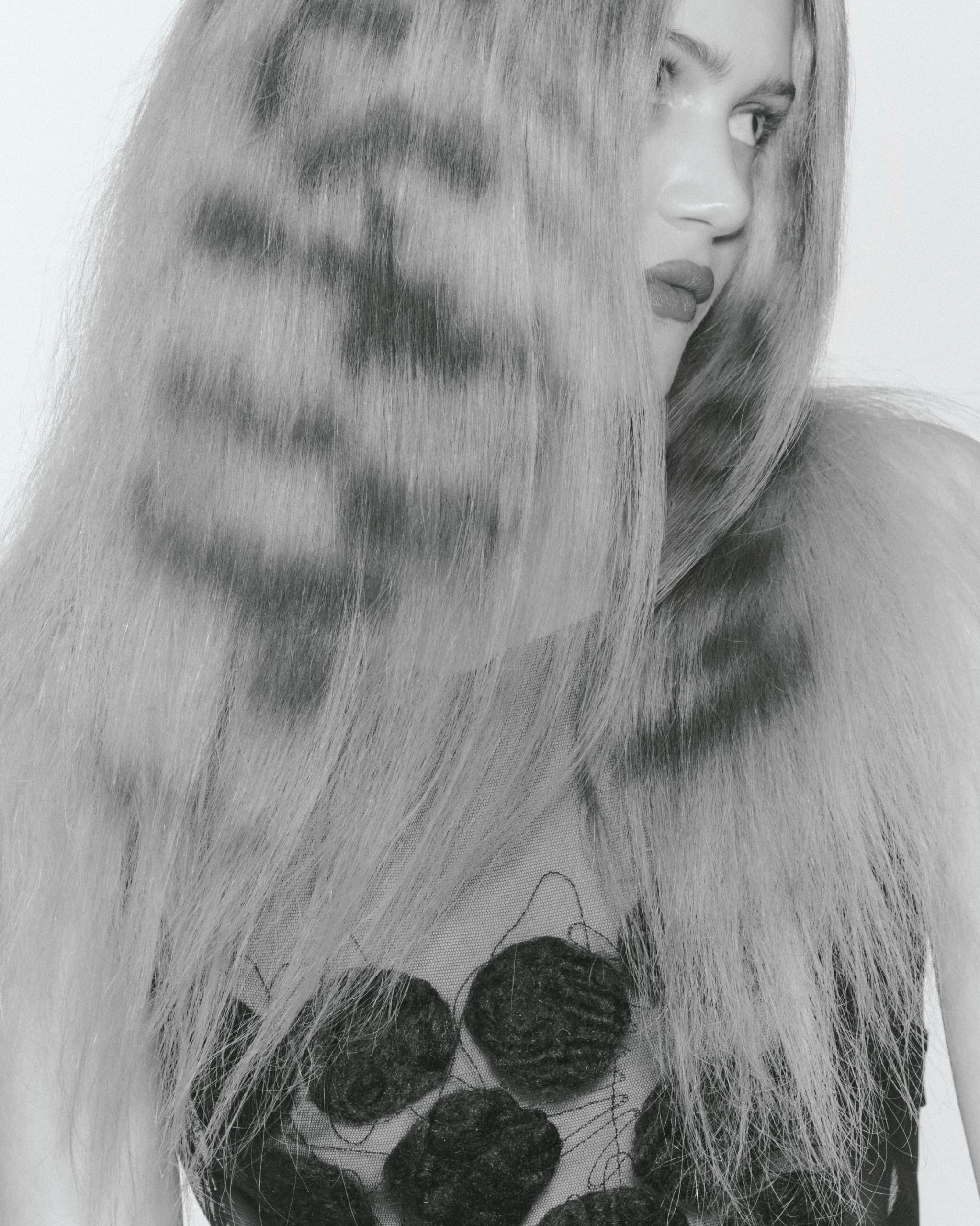Black and white portrait of a woman with textured, voluminous hair.