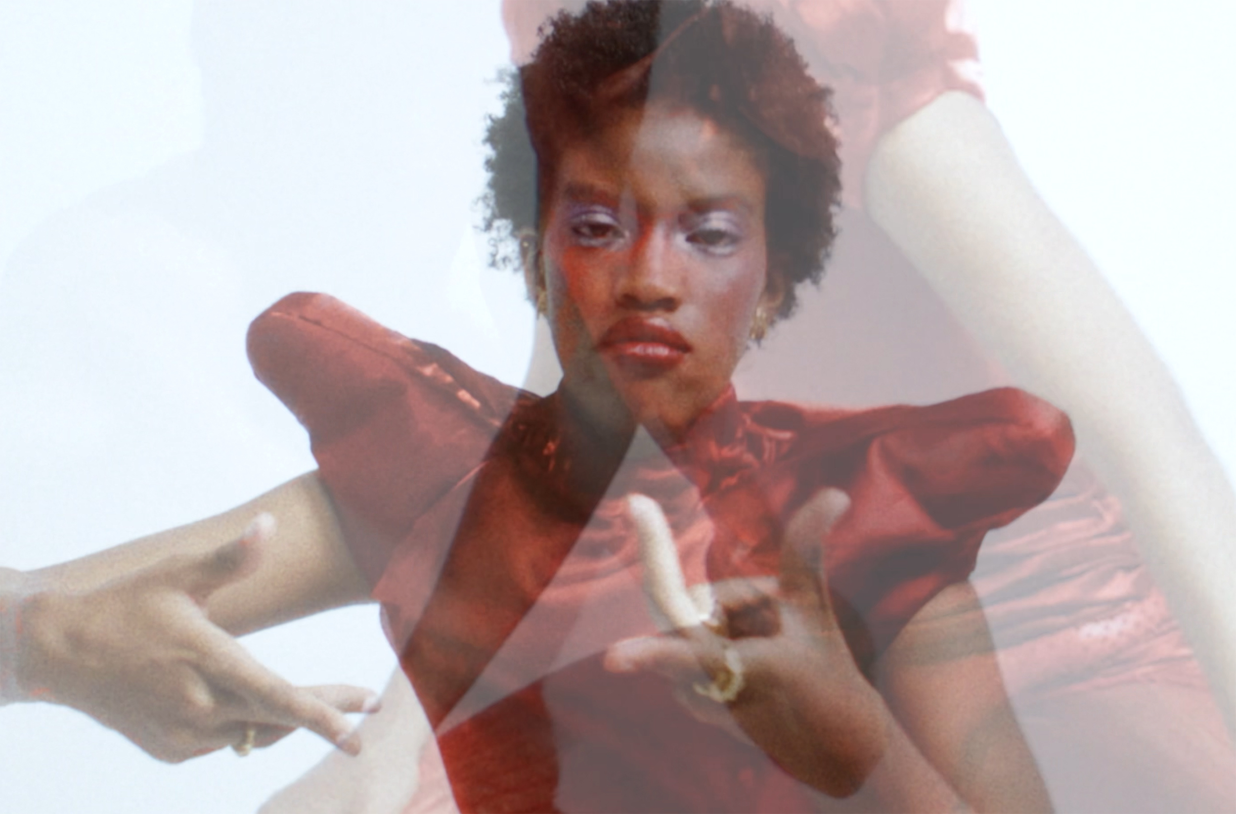 Artistic fashion portrait in layered red dress with dynamic pose.