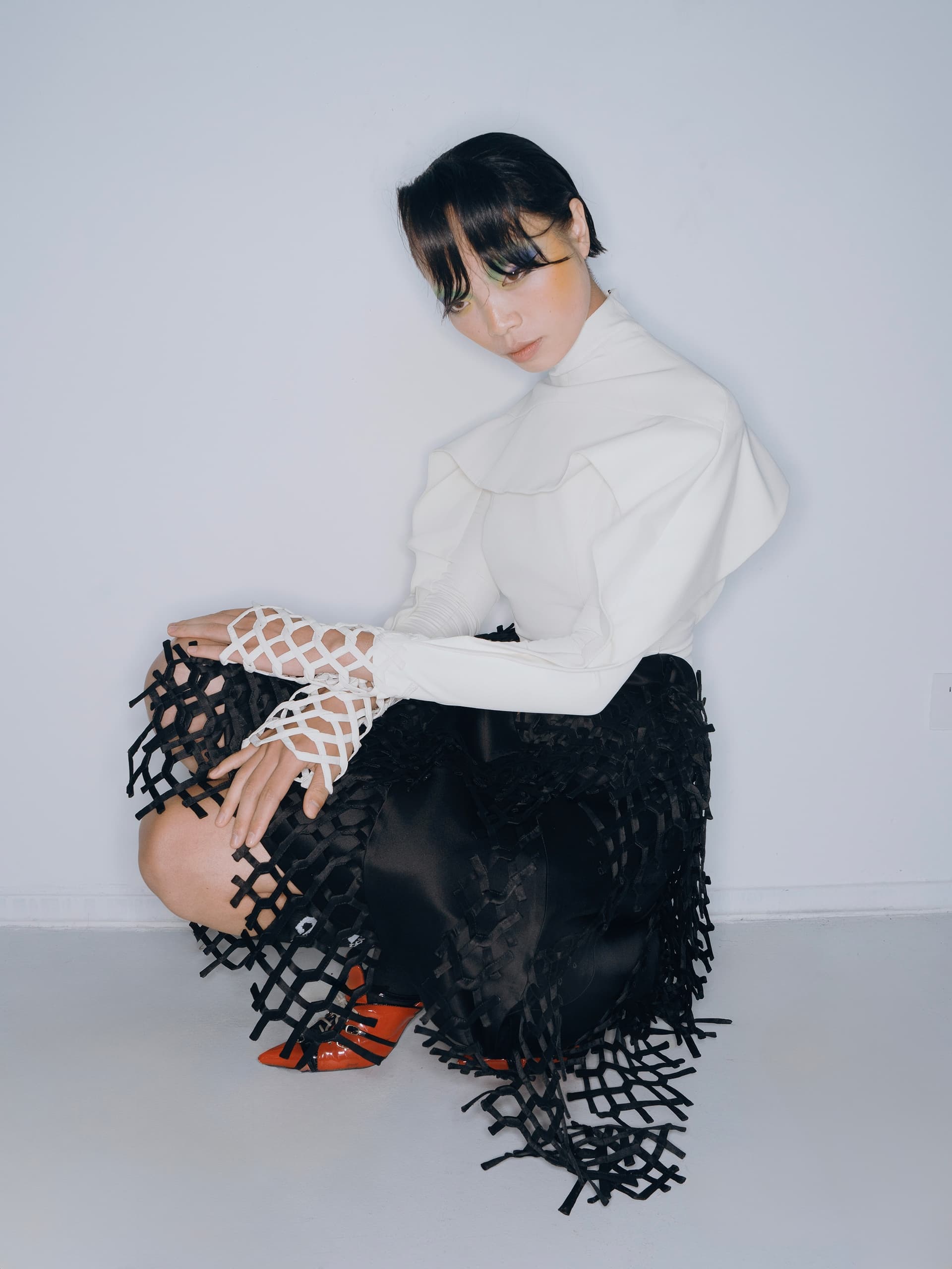 Fashionable outfit with a geometric black skirt and white top on a model.