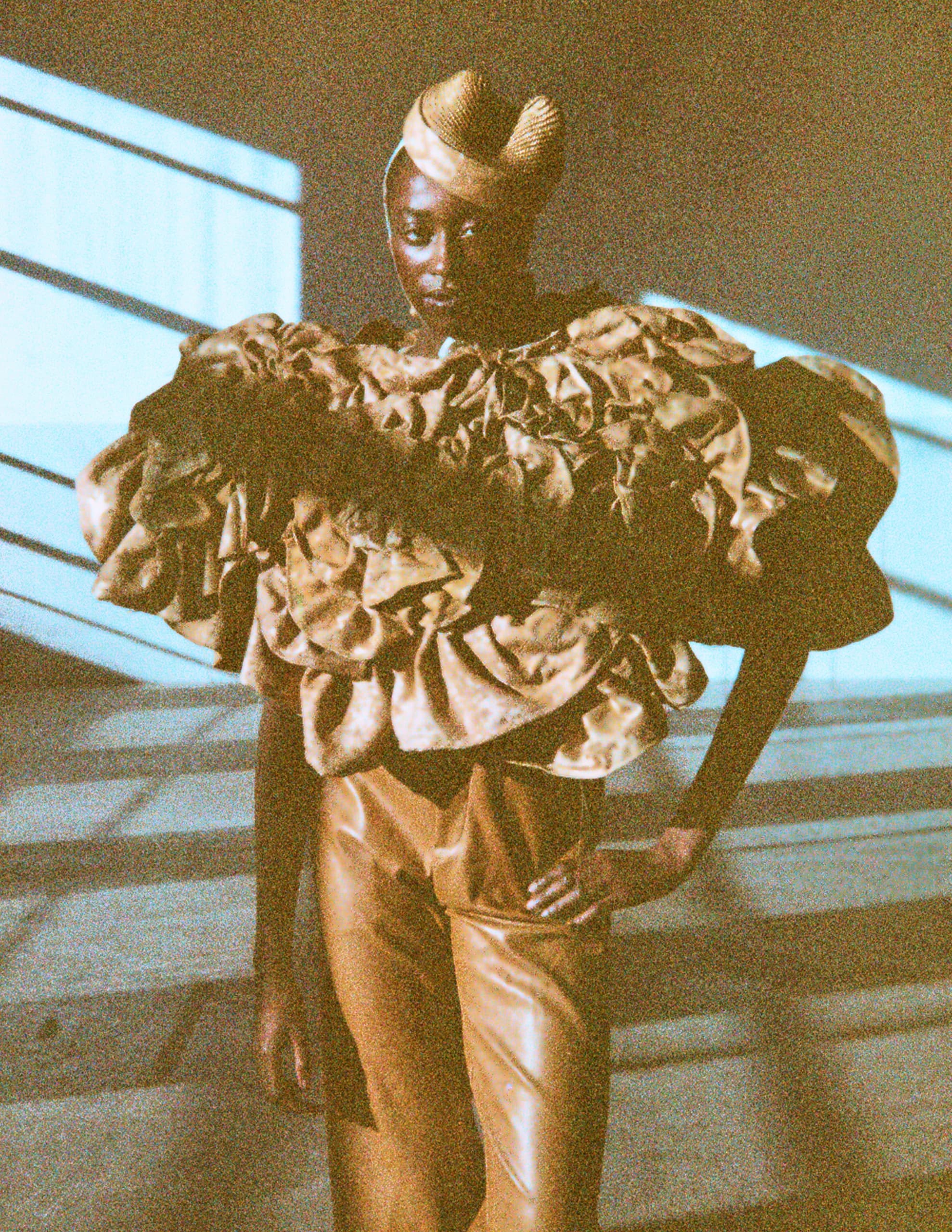 Model wearing a textured outfit with dramatic lighting and shadow effects.