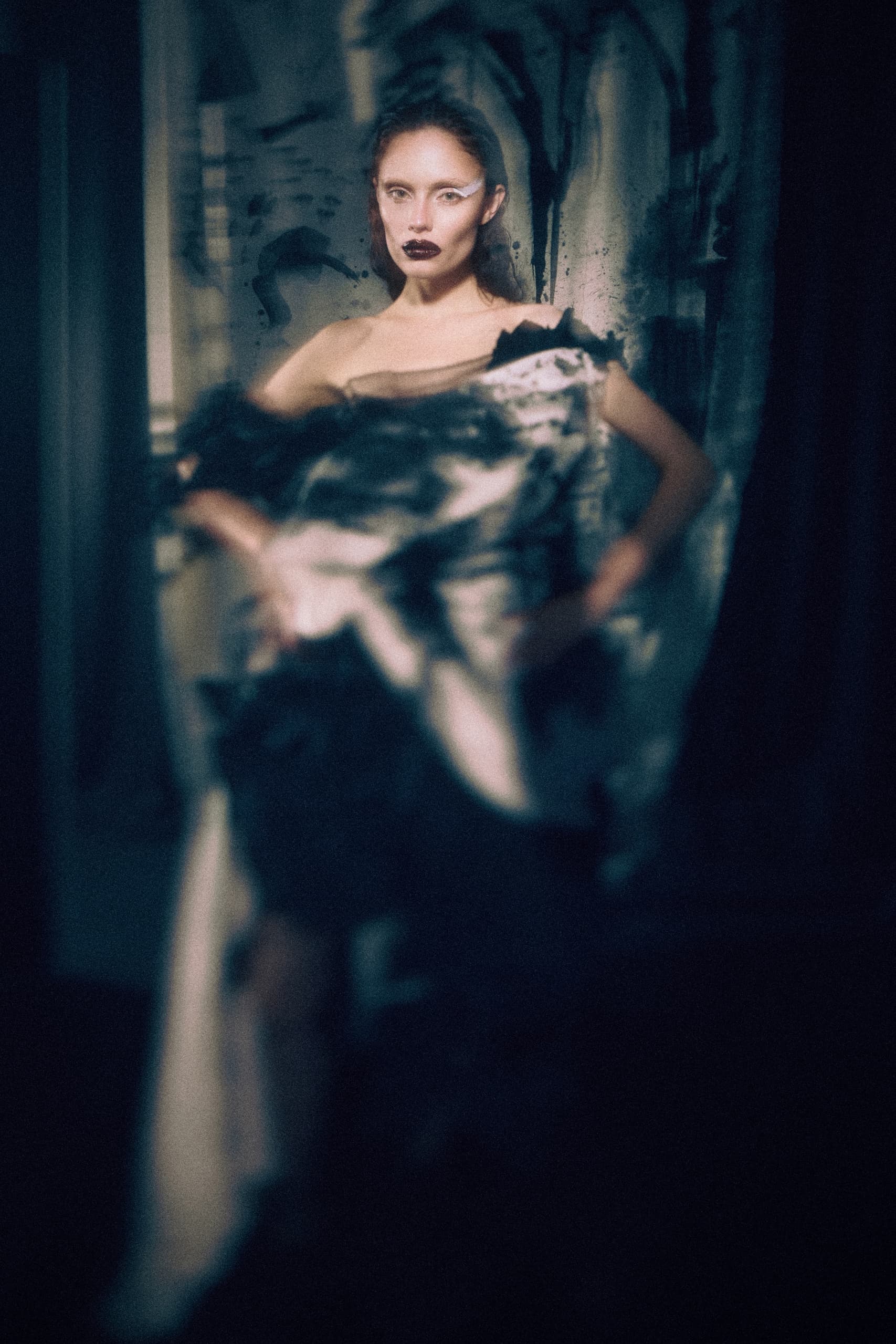 Dramatic fashion portrait with abstract dress and bold makeup.