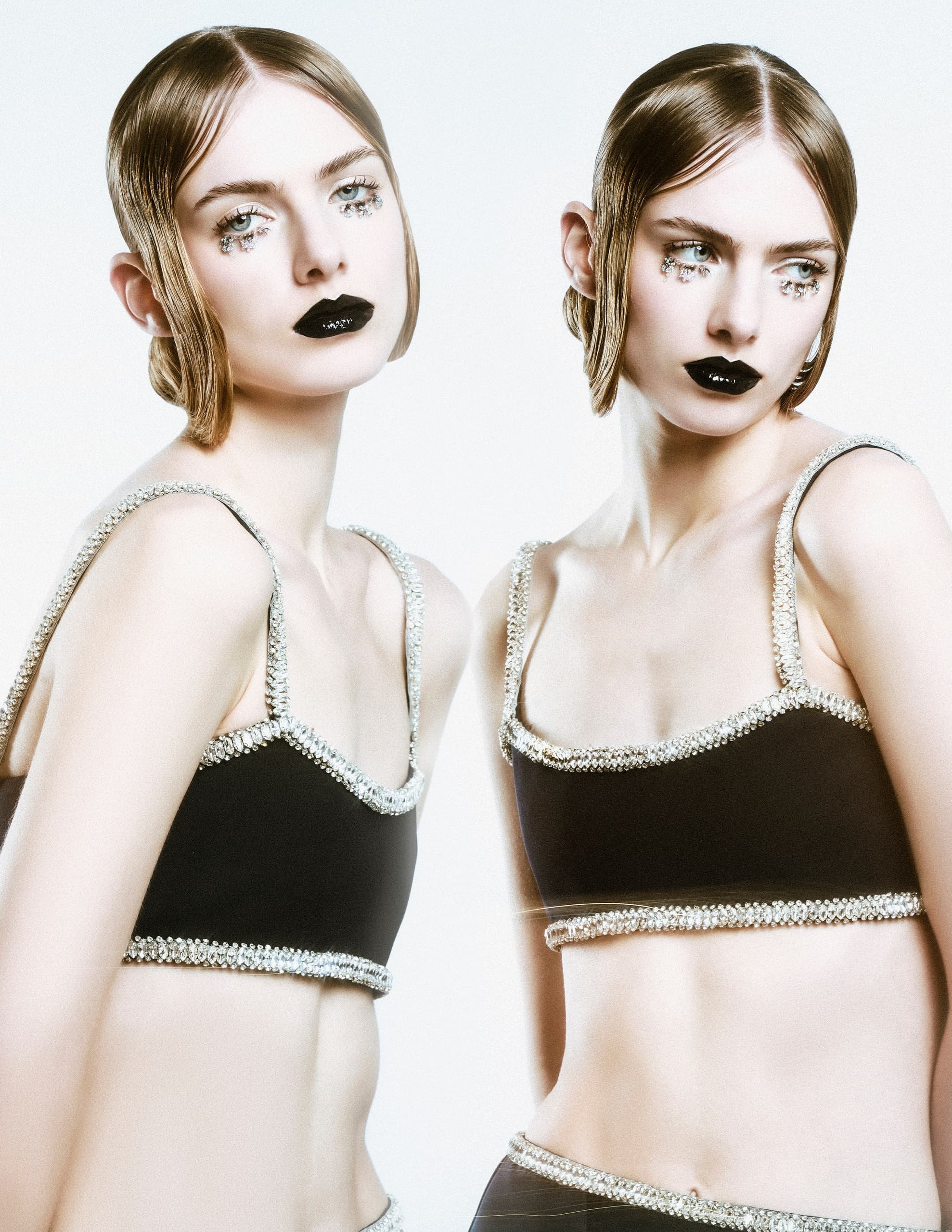 Fashion models in embellished black tops with bold makeup.