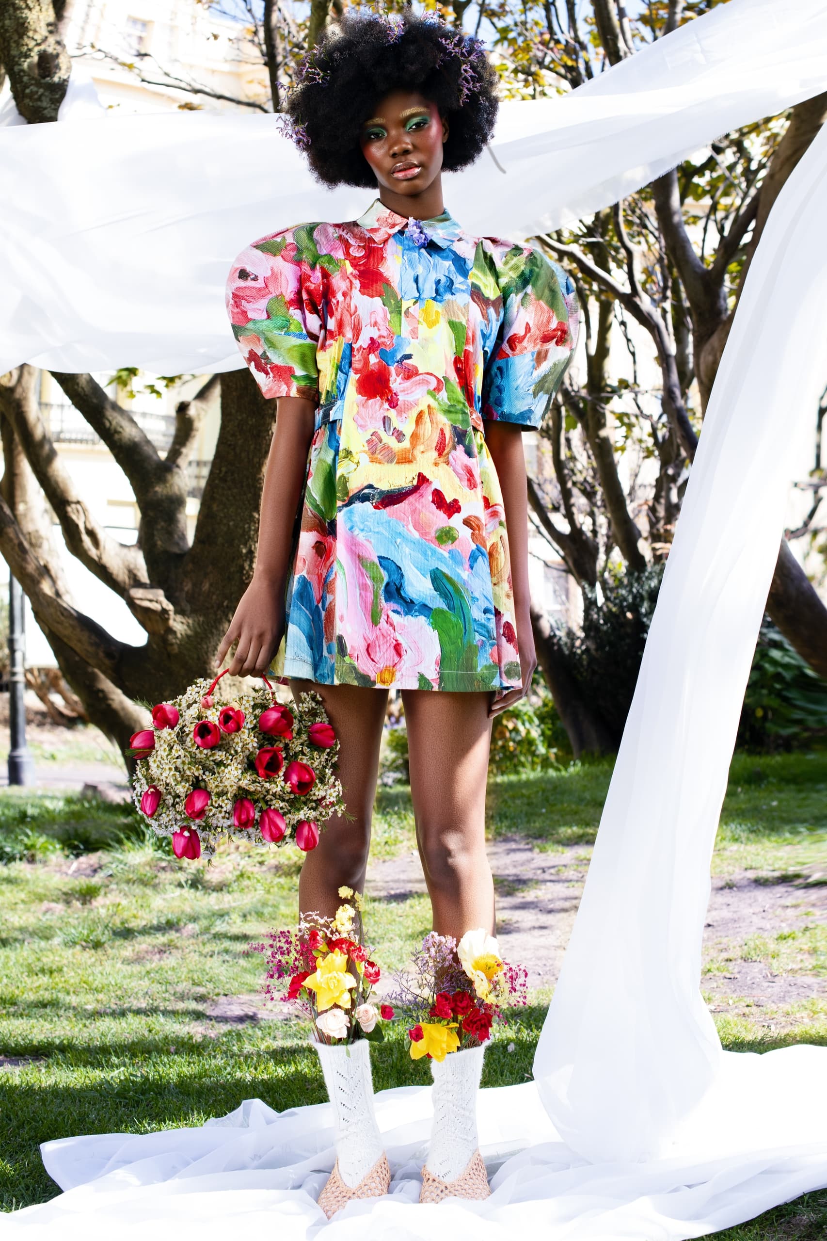 Colorful floral dress with bouquet, outdoor fashion photography.