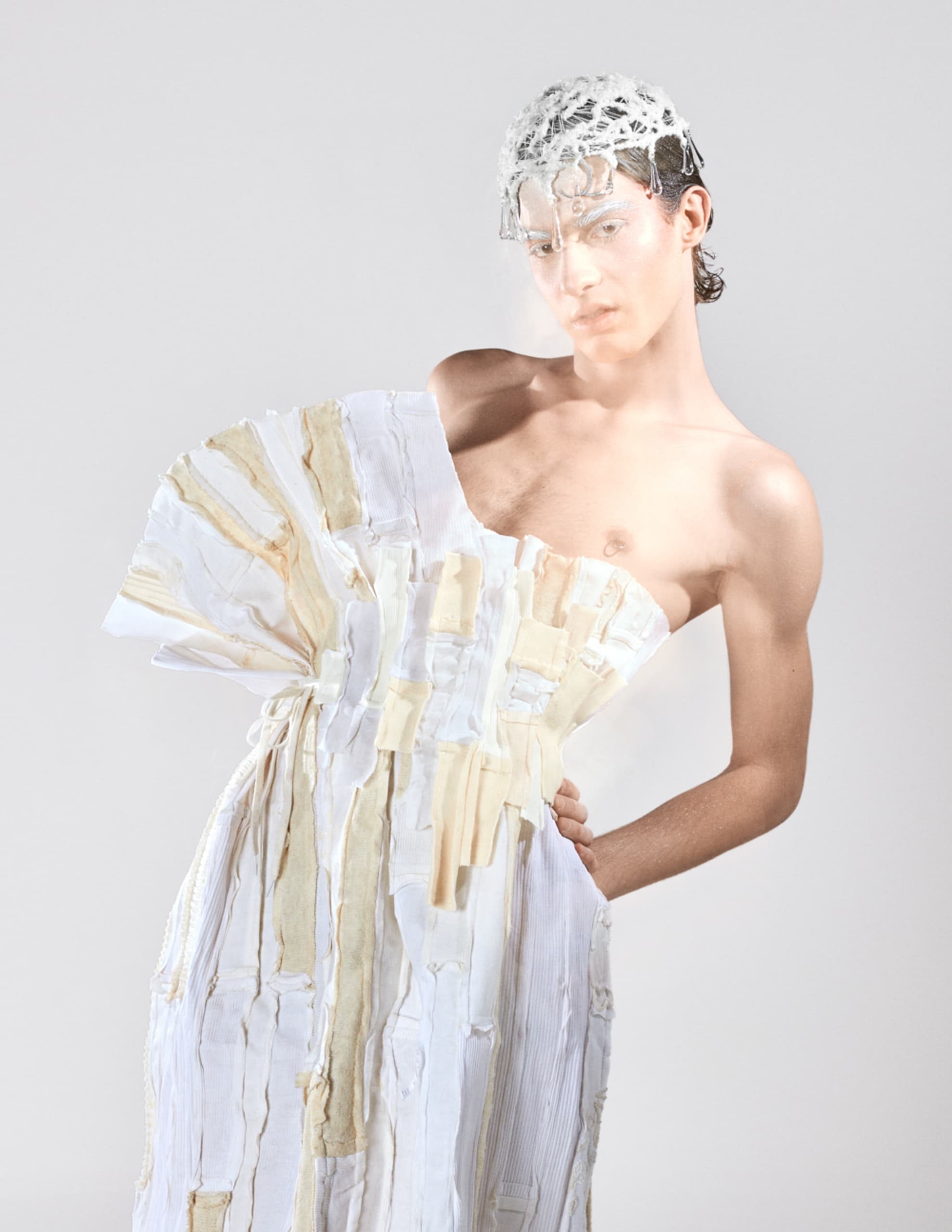 Avant-garde fashion with sculptural dress and intricate headpiece design.