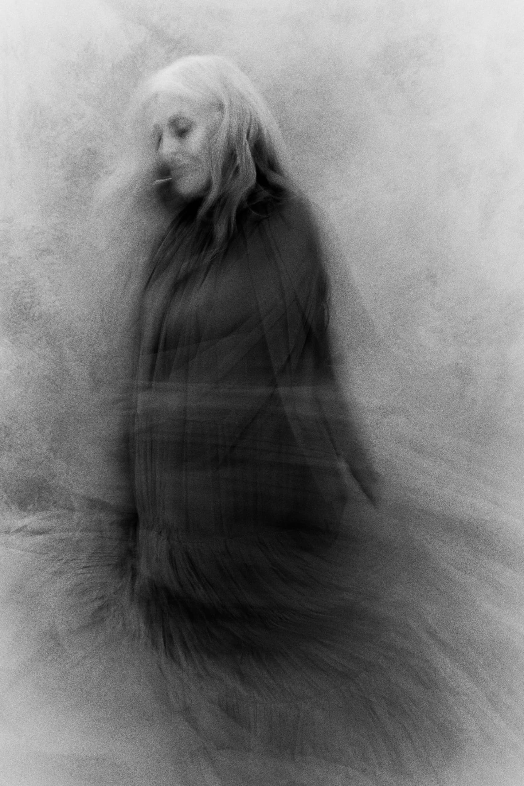 Blurry black and white image of a woman in motion with ethereal effect.